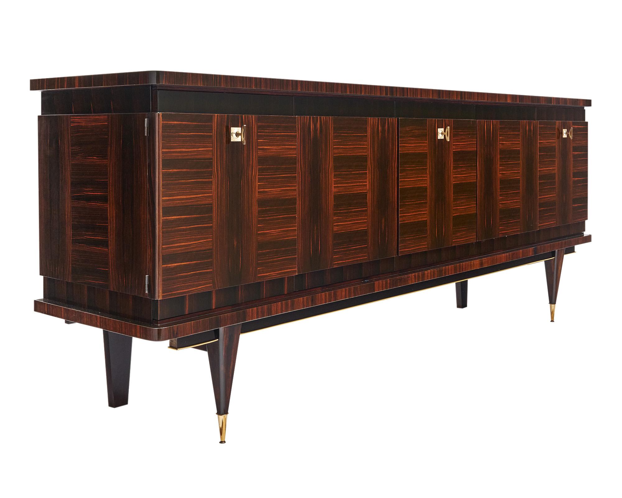 Grand buffet de France avec une façade en Macassar et à la manière de Jules Leleu. Les portes sont dotées de la quincaillerie et des serrures d'origine. Le centre dispose d'une porte qui s'ouvre pour révéler un espace bar avec de la place pour des