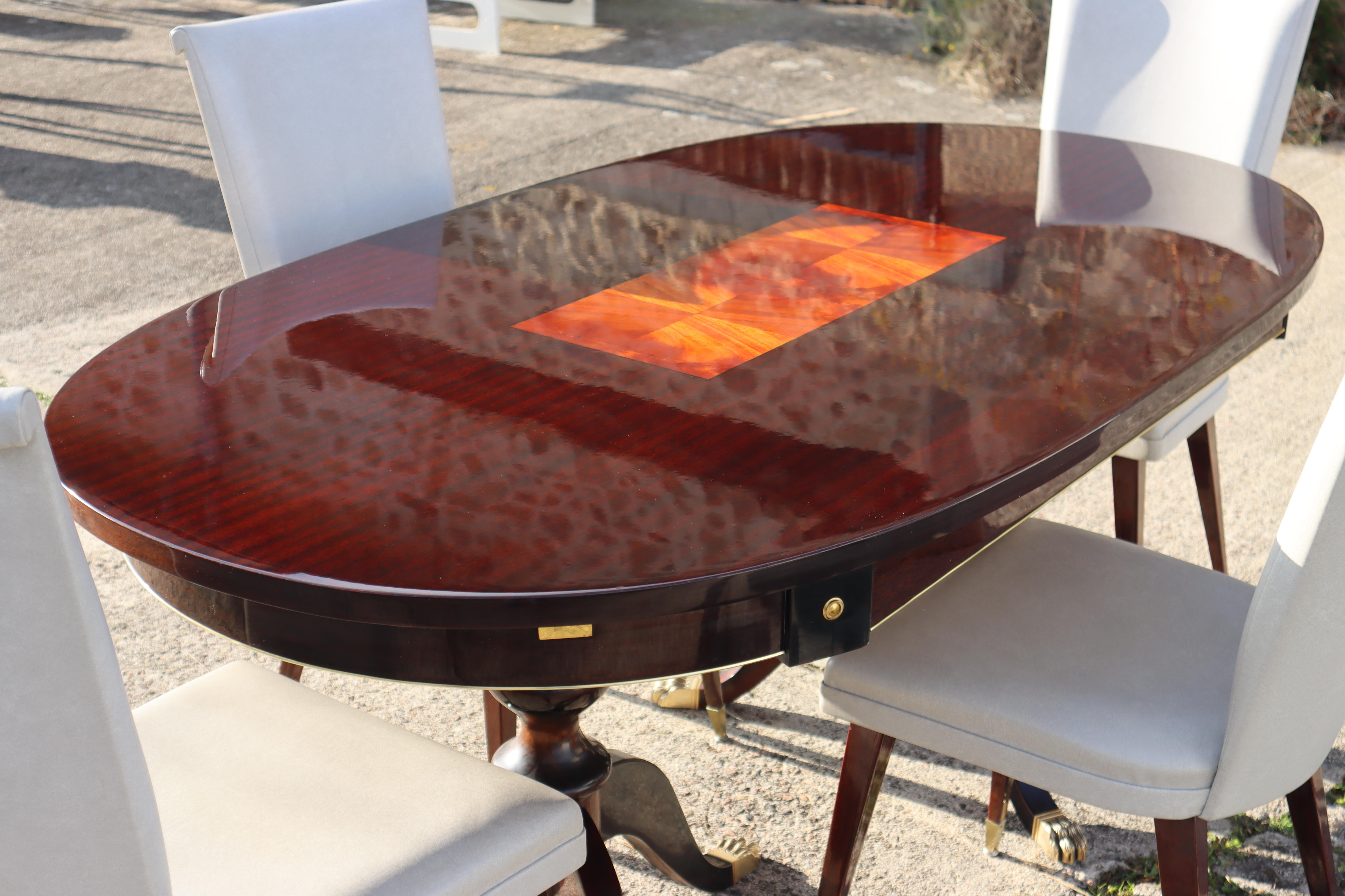 Massive Mahogany oval dining table- Duncan Phyfe style-high gloss dining table from the 80s
High gloss finished table top with stunning Wood Grain and Inlaid work in the center of the table top.
Decorated with subtle Brass Applications on the