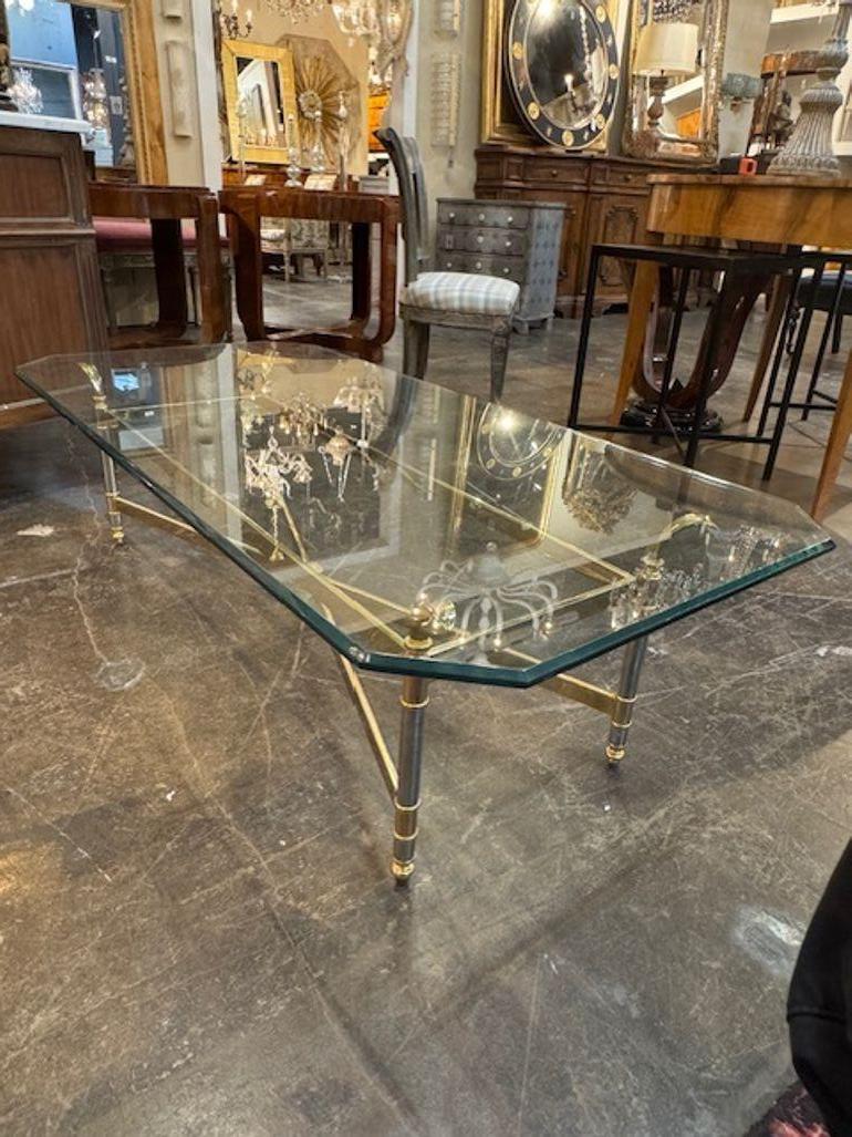 Der Vintage French Maison Jansen Style Brass, Chrome, and Glass Coffee Table ist ein stilvolles und einzigartiges Möbelstück.  Das schlichte Design und die Kombination der Materialien Messing, Chrom und Glas verleihen ihm eine luxuriöse und zeitlose