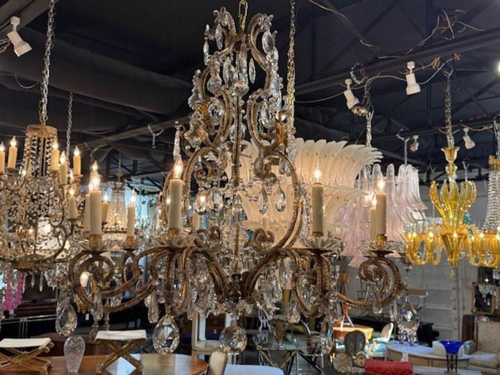 Il lampadario francese d'epoca Maison Bagues in ferro dorato e cristallo è un apparecchio straordinario,  perfetto per aggiungere un tocco di eleganza a qualsiasi ambiente. Realizzato in ferro dorato in forma decorativa e ornato da accenti di