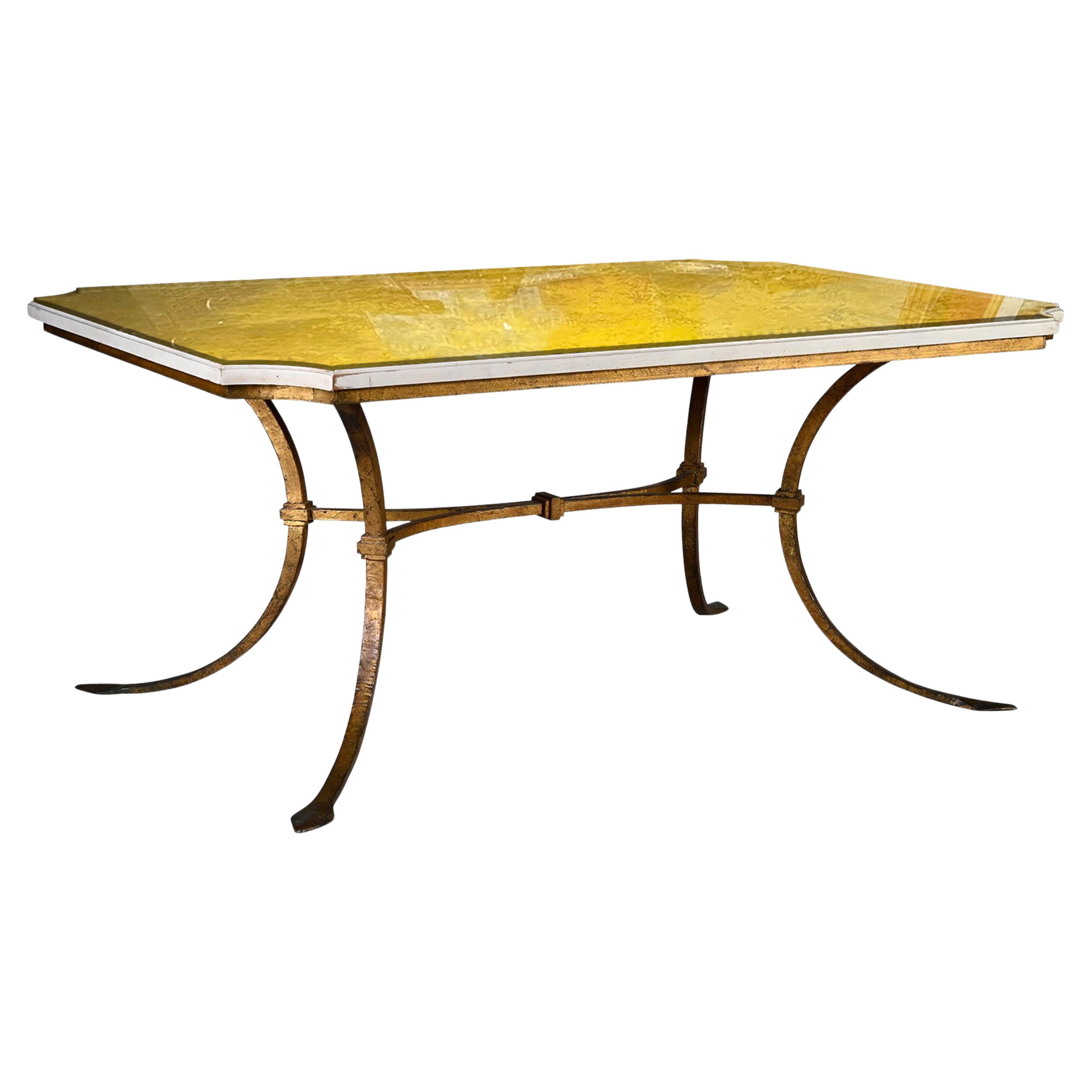 Forged and gilded dining table, standing on four curved legs joined by an X brace, the rectangular top in lacquered wood and yellow hand painted glass.
Work from the 1940s.
Haut.: 74 cm - Larg.: 161 cm - Prof.: 111 cm