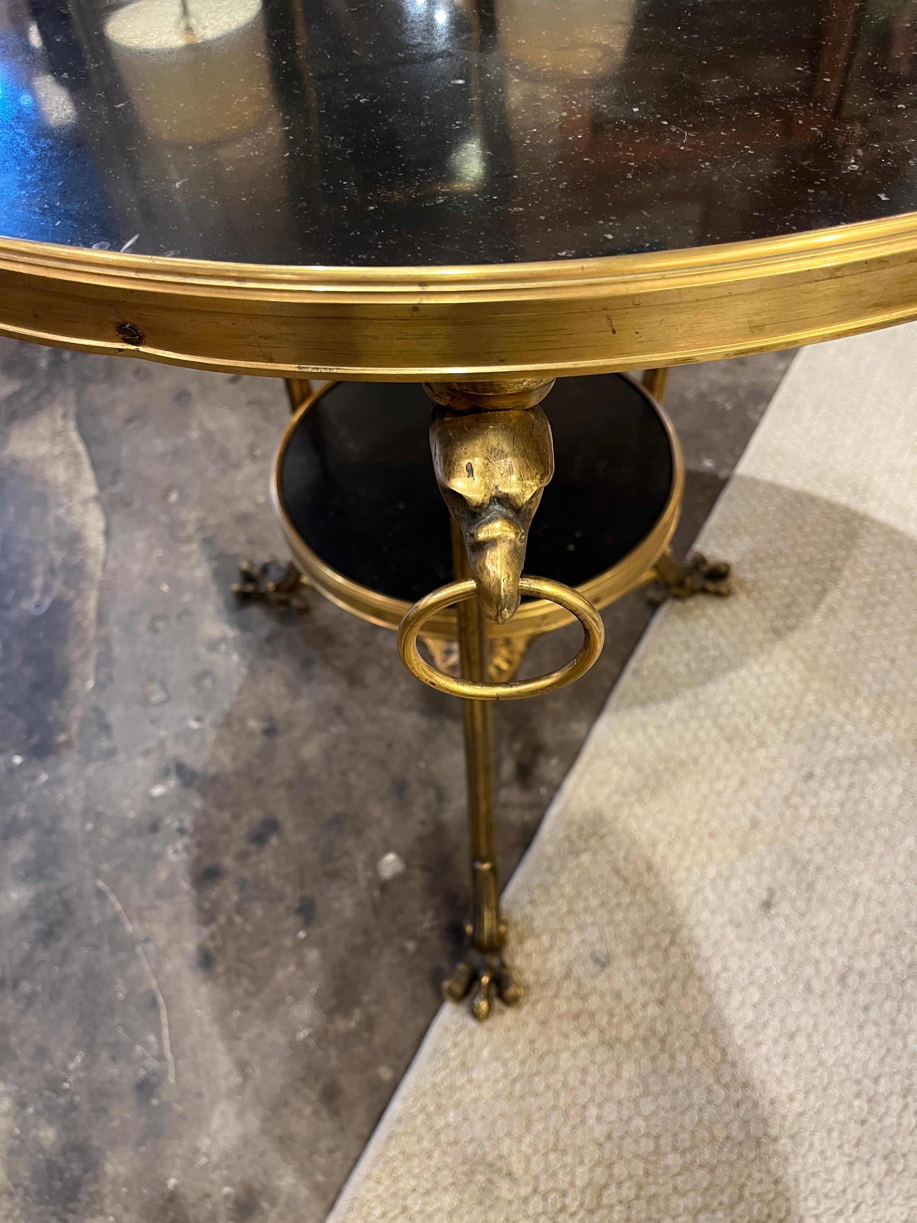 A Vintage French black marble gueridon table having ormolu serpent ring handles.