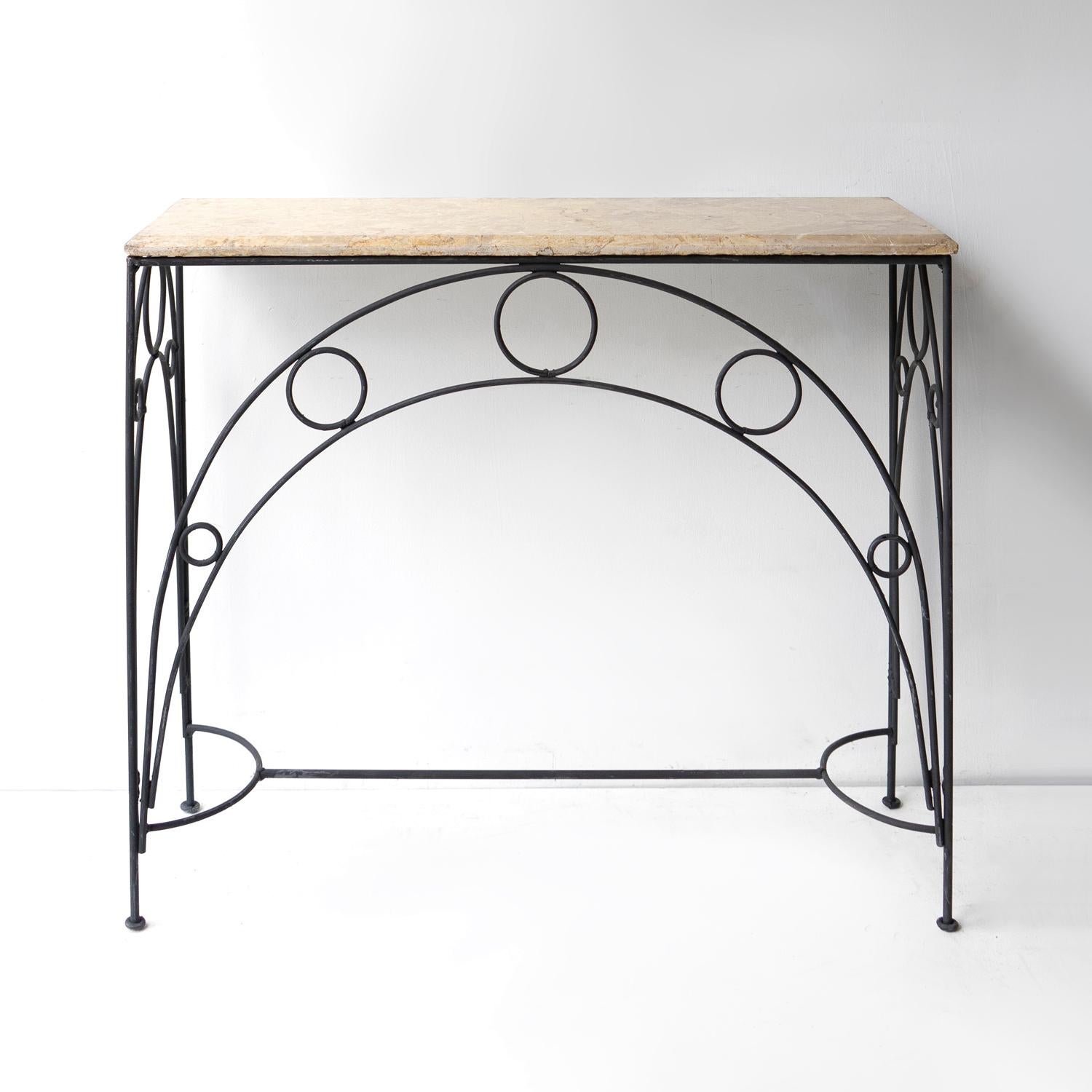 VINTAGE CONSOLE TABLE
Of elegant proportions with a natural solid marble top which has wonderful character and sits on a wrought metal base with arched and circular decoration.

Probably originated in France and dating from the Mid-20th