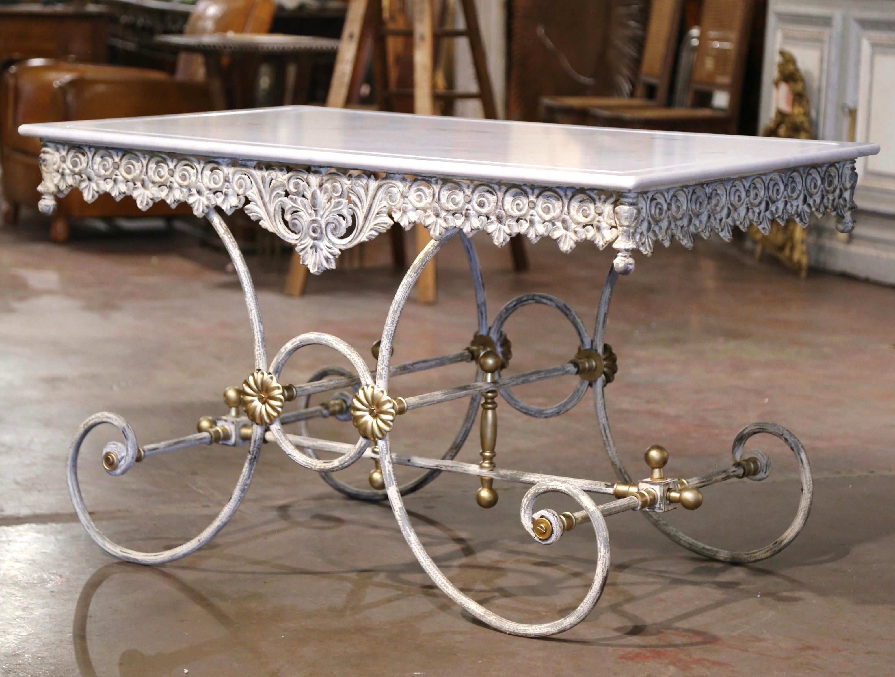 This French butcher table, or pastry table would add the ideal amount of surface space to any kitchen. Crafted in France, the table stands on four scrolled legs over an intricate stretcher and decorative bronze rosettes and finials. The table