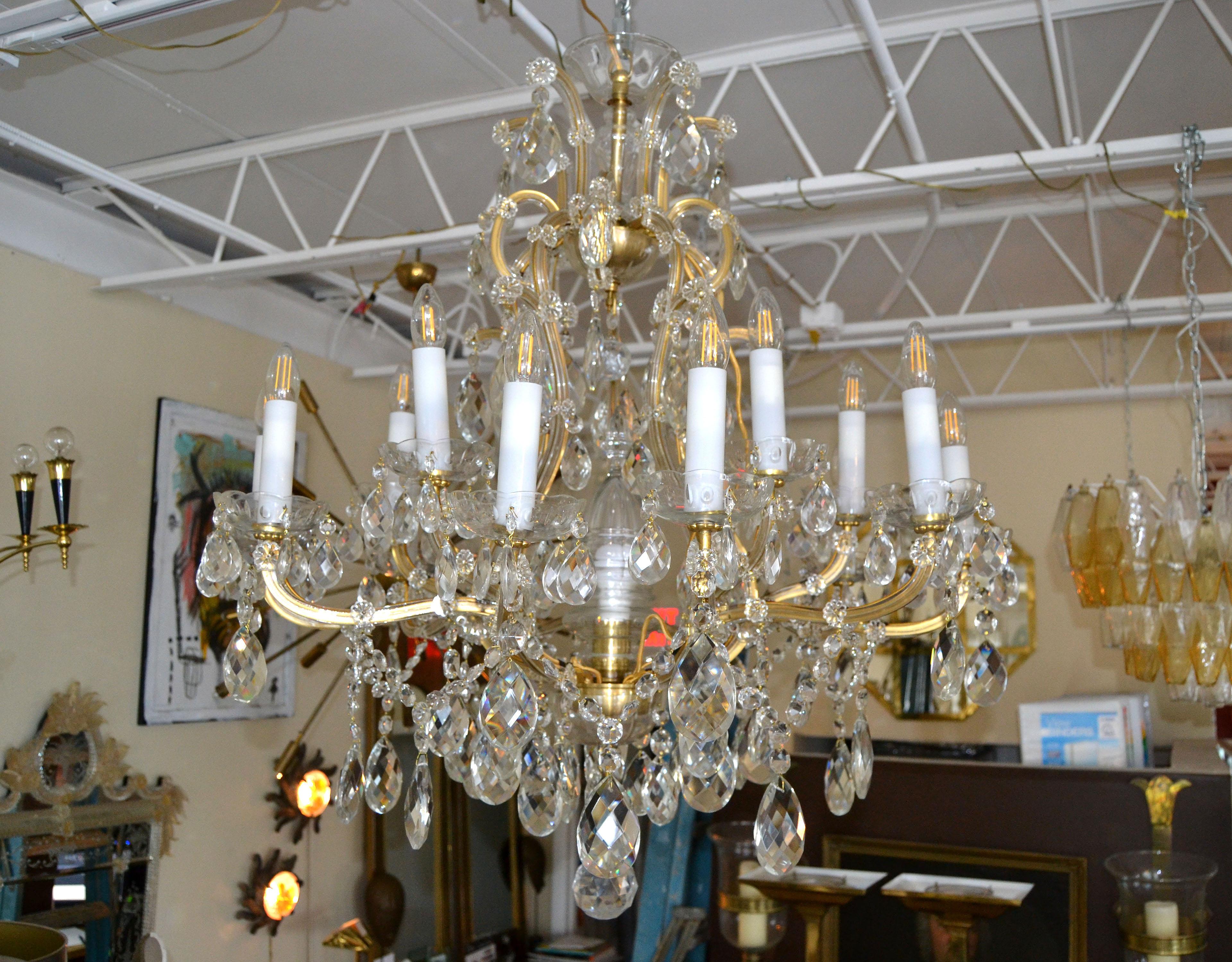 A glamorous Maria Theresa sixteenth-light chandelier or hanging fixture (35 inches diameter) of faceted crystal, cut glass and gilt metal featuring serpentine arms.
Made in Czechoslovakia and each candlelight with Bohemian glass flowers, dangling