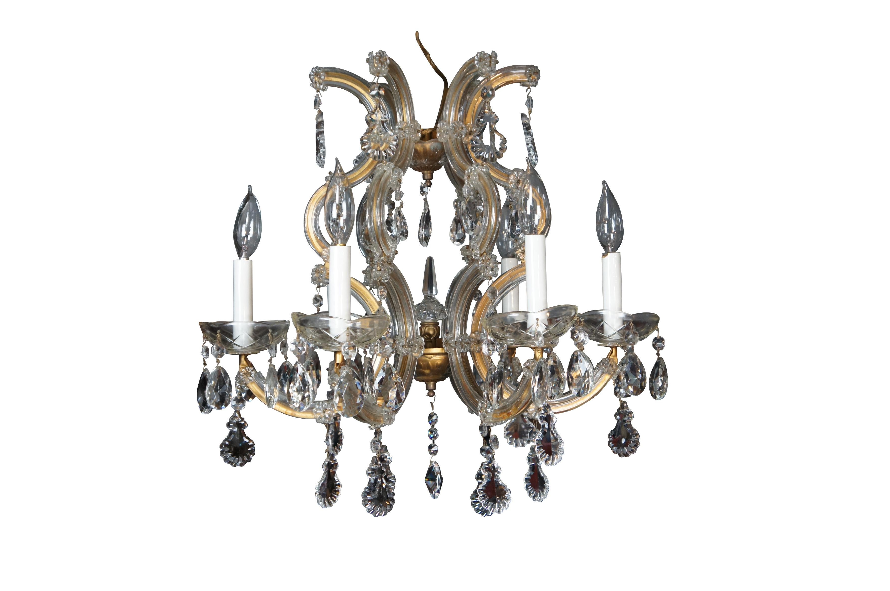 Vintage French Marie Therese glass clad brass drop crystal six arm chandelier featuring serpentine form with candlestick lights.

Maria Theresa chandeliers, which were named after Austria’s Empress Maria Theresa, are antique crystal lighting
