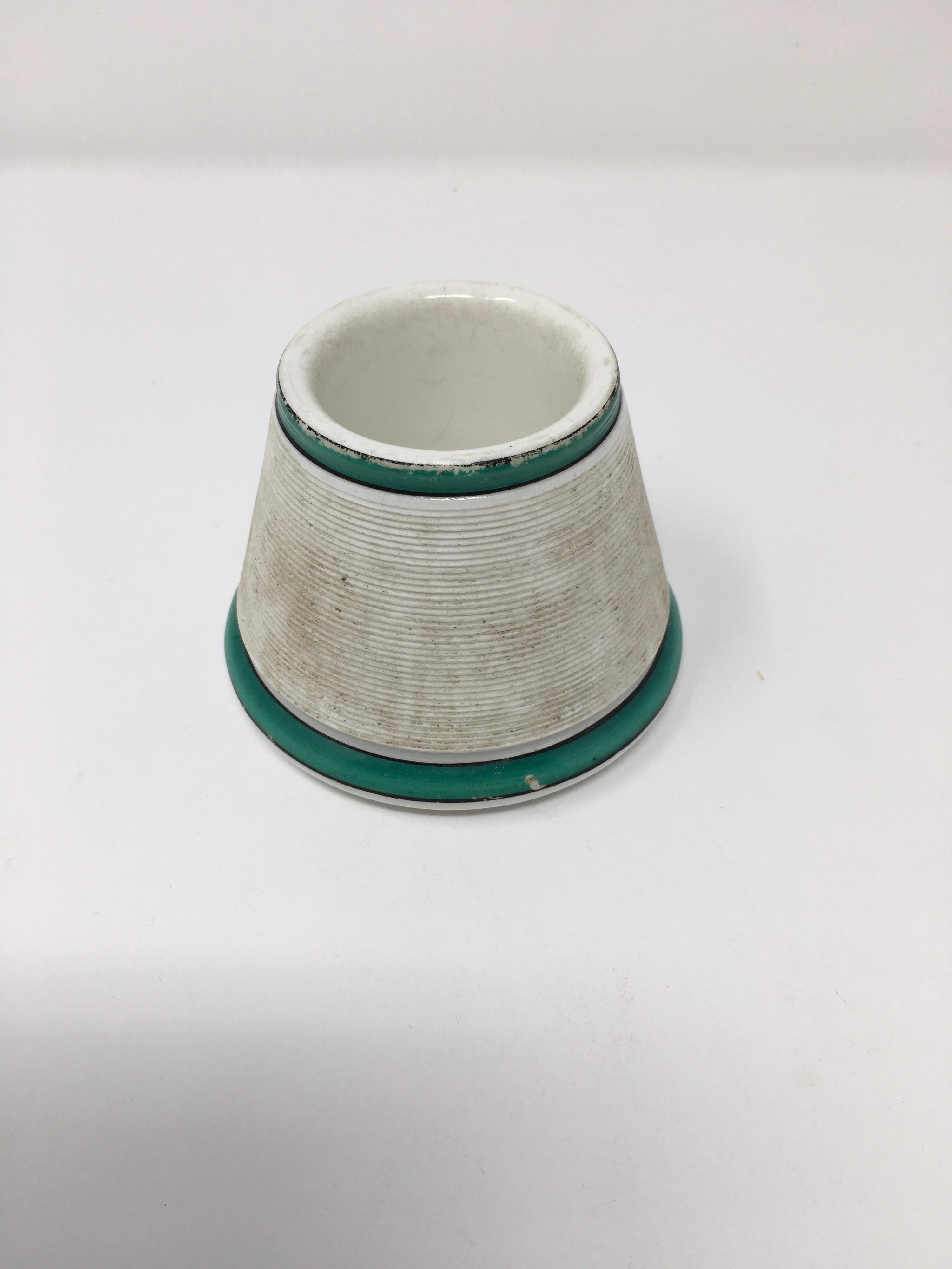 This is a French match holder and striker of white porcelain with two bands of green and black around the top and base. A great gift for the collector or to start a collection of your own.