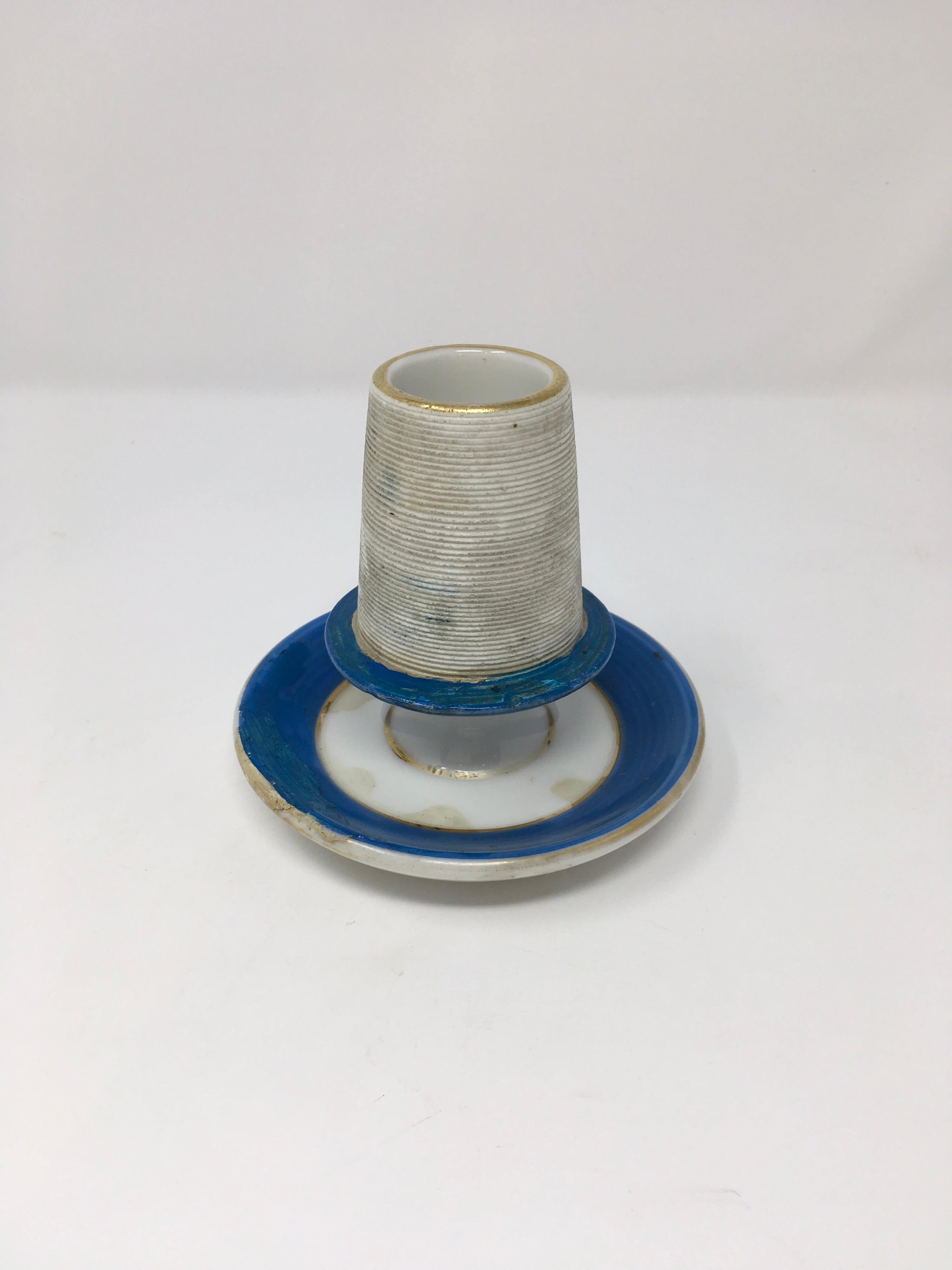 This is a French match holder and striker made of white porcelain with bands of blue around the top and base. A perfect gift for the collector or to start a collection of your own.