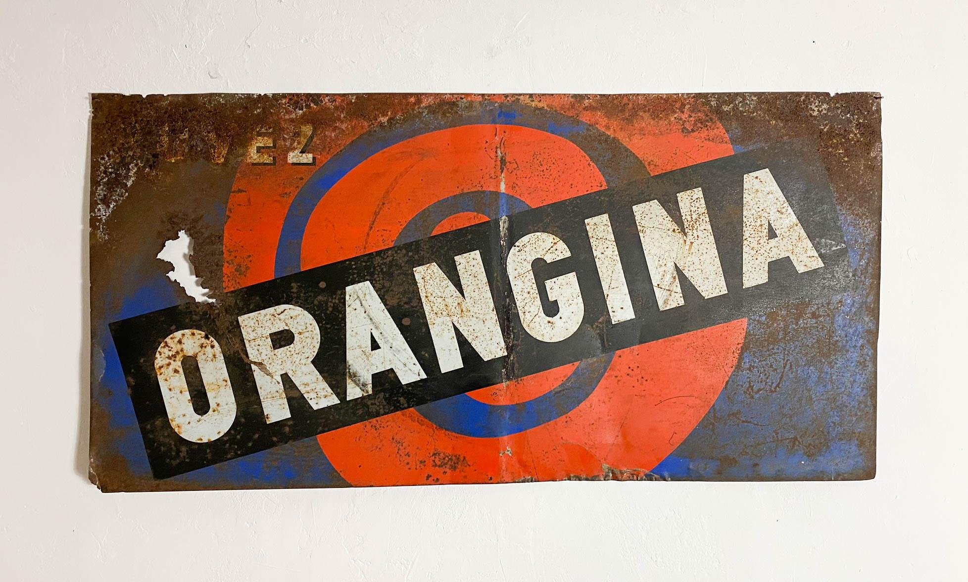 A rare and highly collectable metal advertising sign from the iconic brand Orangina, dating from the 1960s. It has some damage and areas of rust which enhance the character and patina of the sign. Bright and vibrant, it would make a brilliant sign