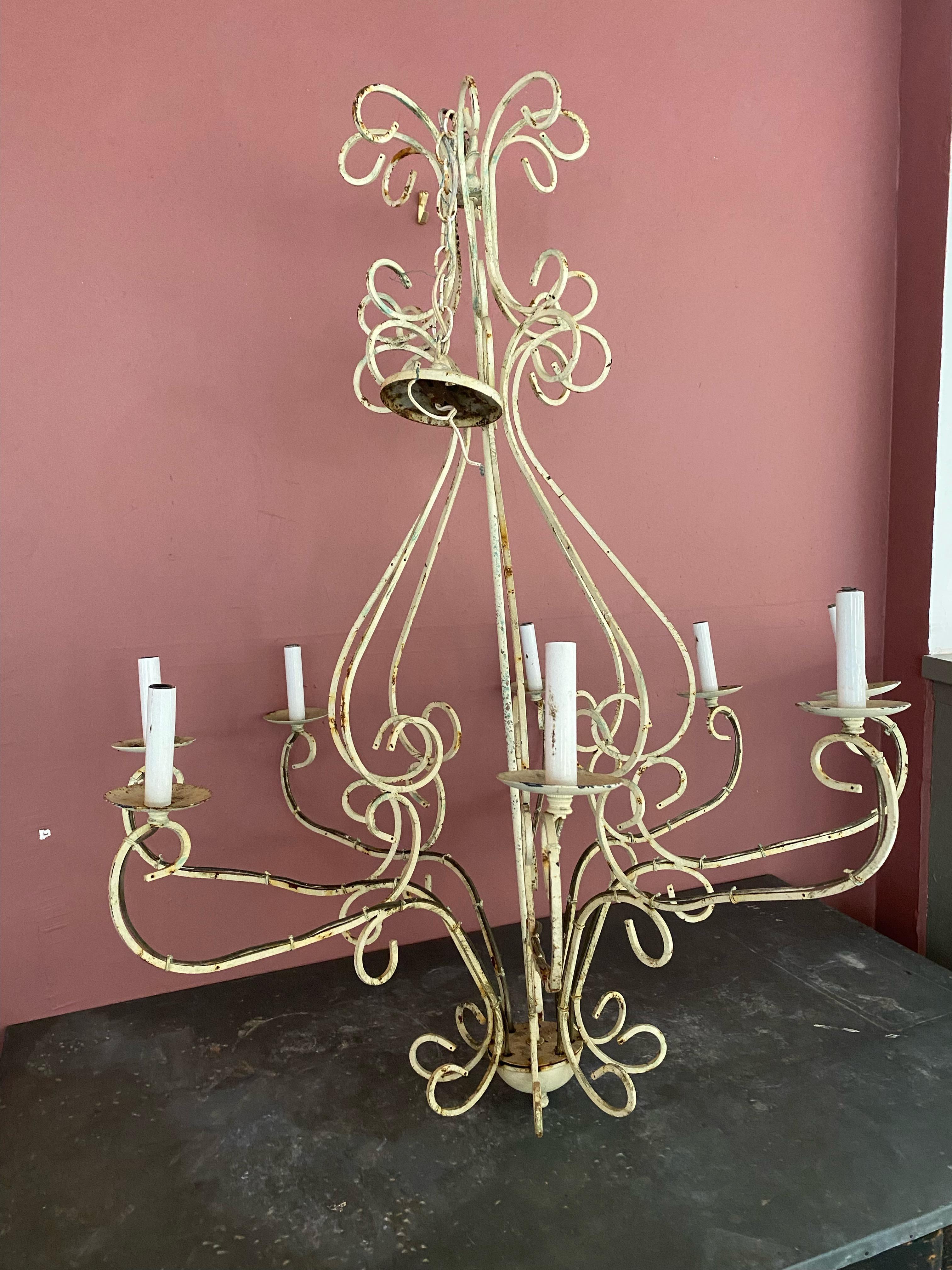 This chandelier serves as a focal point of rustic elegance, full of unique charm and character. Each intricately designed wrought iron detail evokes a sense of romance, capturing the essence of French provincial style. Eight lilypad candlestick