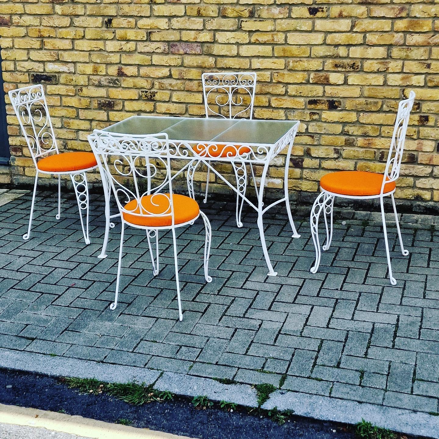 Dies ist ein kompaktes Gartenset mit dekorativem Glastisch aus Metall und 4 orangefarbenen Stühlen mit Sitzfläche.

Französisch aus den 1950er Jahren.