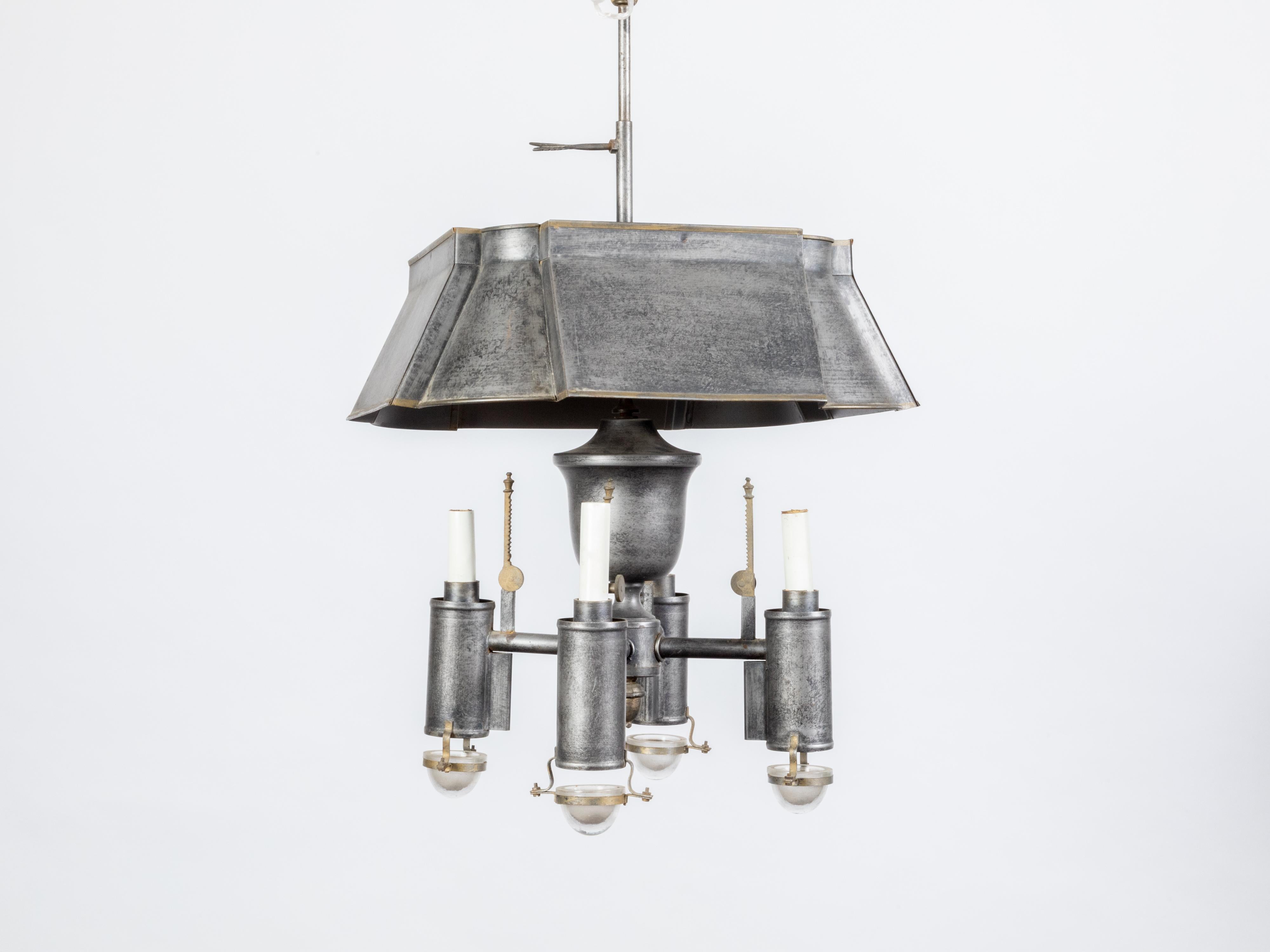 A French tôle chandelier from the mid 20th century, with four lights and glass cups. Created in France during the midcentury period, this tôle chandelier features a square shaped tôle shade with rounded corners, sitting above a central baluster