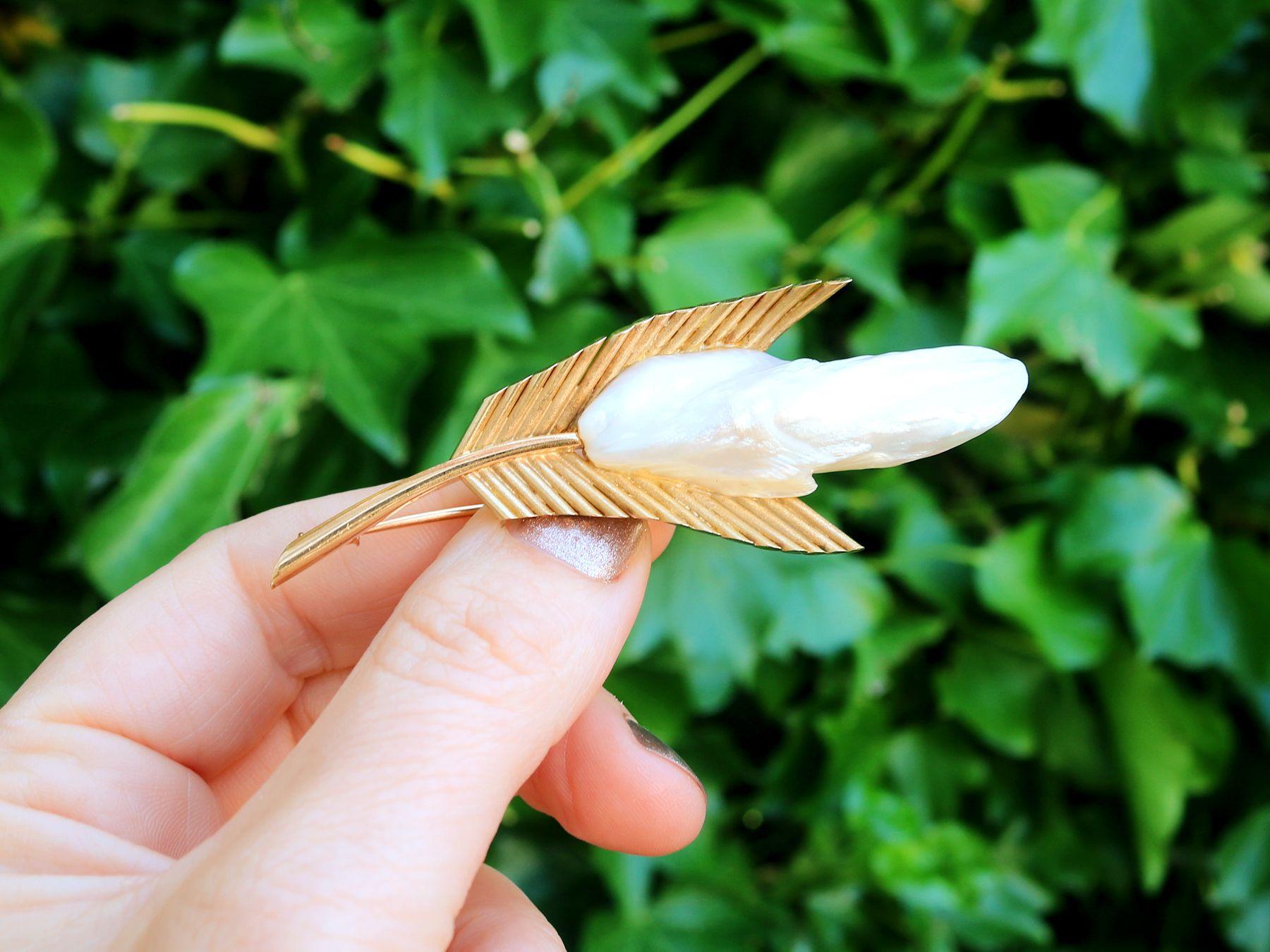 A stunning, fine and impressive vintage Mississippi river pearl and 18 karat yellow gold brooch in the form of a feather; part of our diverse vintage jewelry collections.

This stunning vintage French vintage pearl brooch has been crafted in 18k