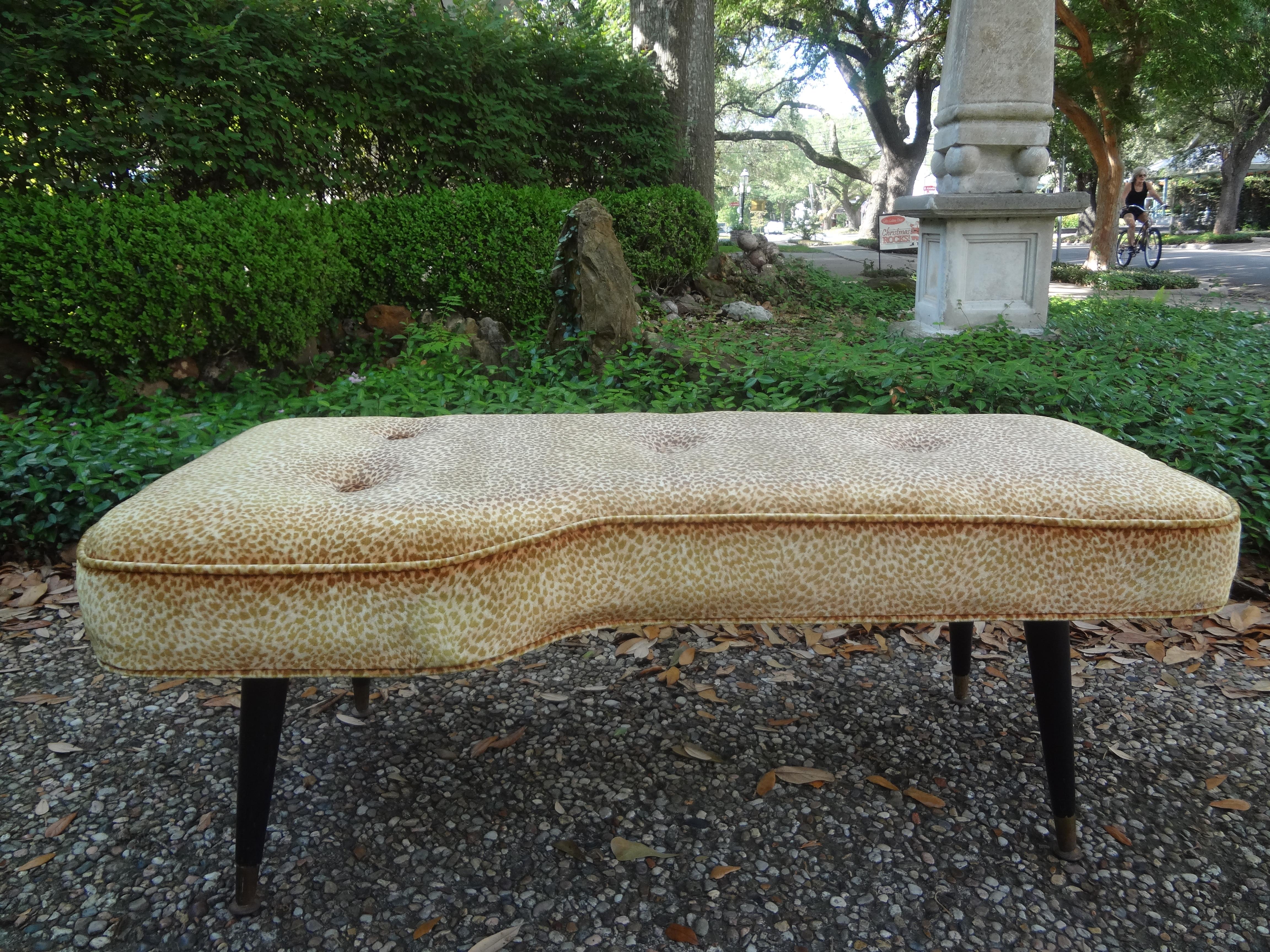 French Modern curved bench After André Arbus. This shapely vintage French bench has ebonized legs terminating in brass sabots. Recently upholstered in animal print velvet but easy to newly upholster in the fabric of your choice. Great addition to