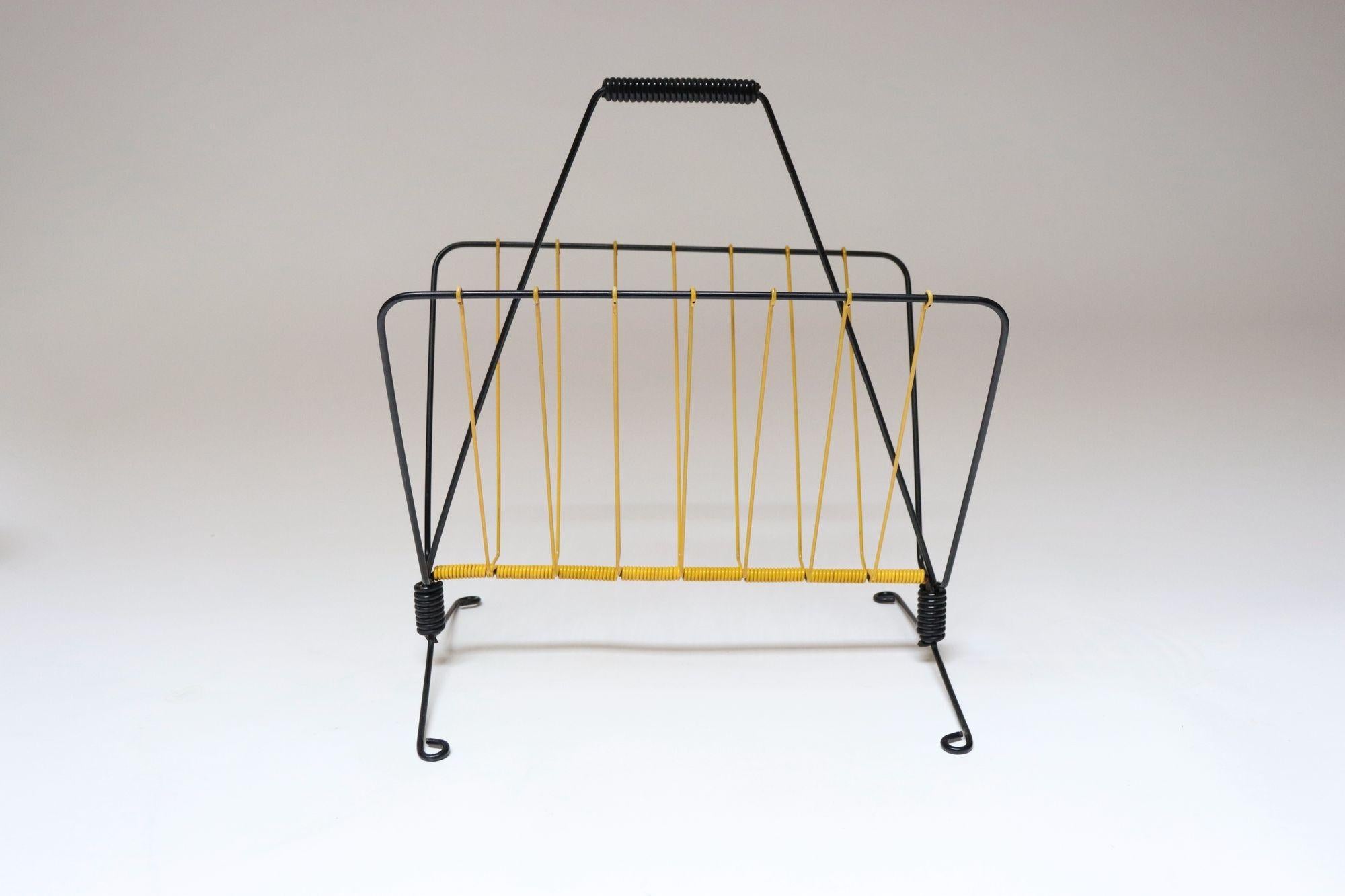 Porte-revues français en fil de scoubidou jaune et métal noir (vers 1950).
La forme est élégante et moderniste et les couleurs sont attrayantes.
Excellent état vintage avec seulement de légères éraflures, comme indiqué.
H : 15.88