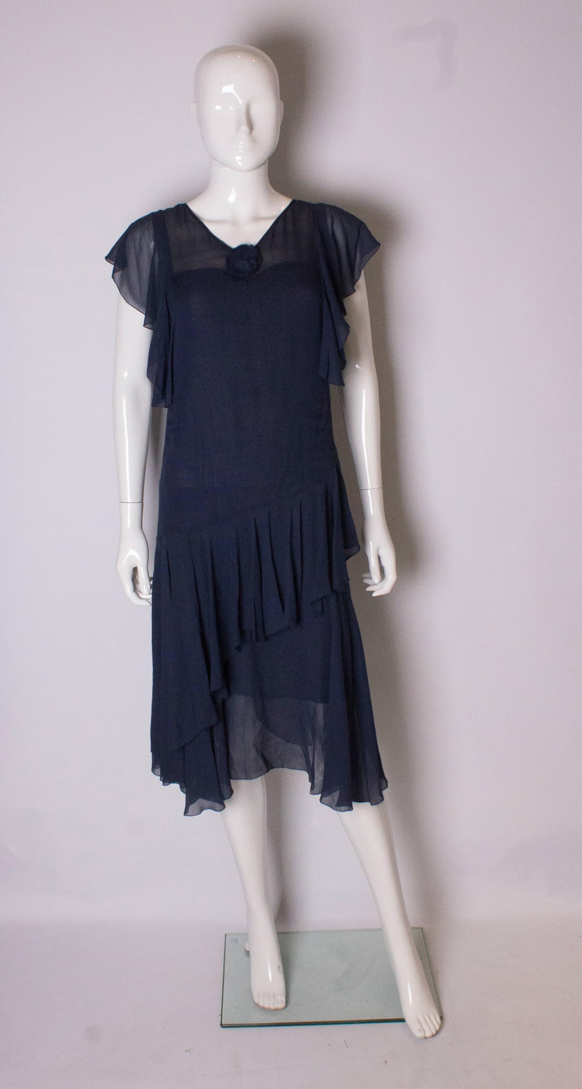 A pretty vintage French navy dress from the 1930s. In a chiffon like fabric, the dress has a v neckline, cap sleeves , diagonal frills at the front, and frills at the back. It is fully lined.