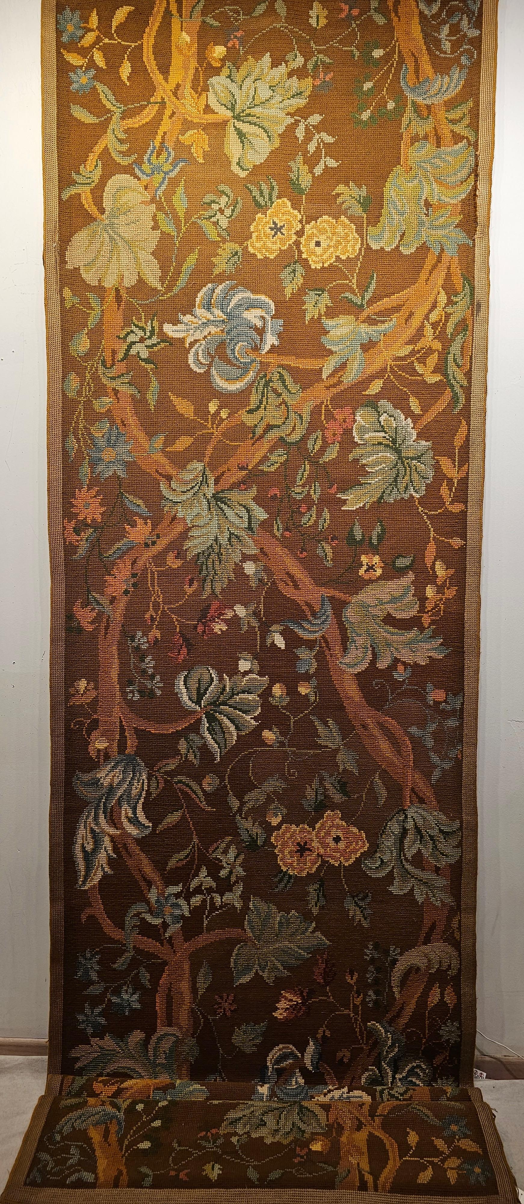  A beautiful French hand woven Needlepoint runner from the early 1900s.  The Needlepoint has a  symmetric design depicting trees emanating toward the heavens with curving branches that have color full leaves with various shades of green, blue,