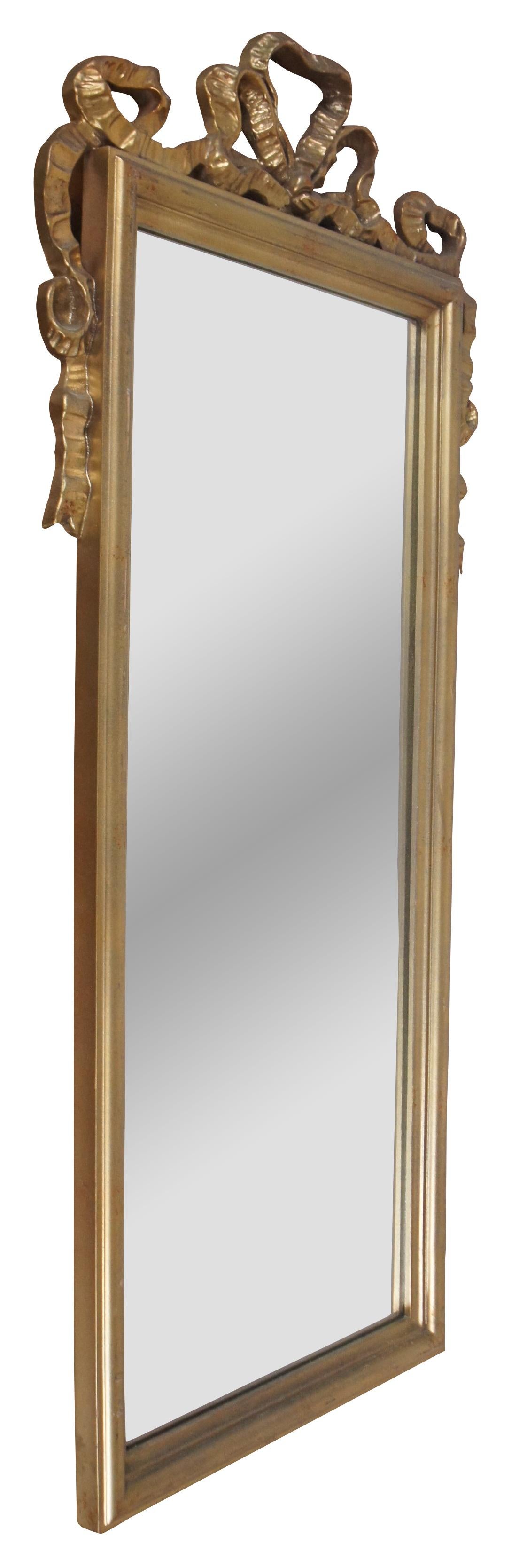 Vintage French Neoclassical Napoleon III style gold gilt wall mirror with beveled rectangular frame topped with carved ribbons.

Measures: 18.5” x 1.125” x 38.25” / Mirror - 12.25” x 30.5” (Width x Depth x Height).
