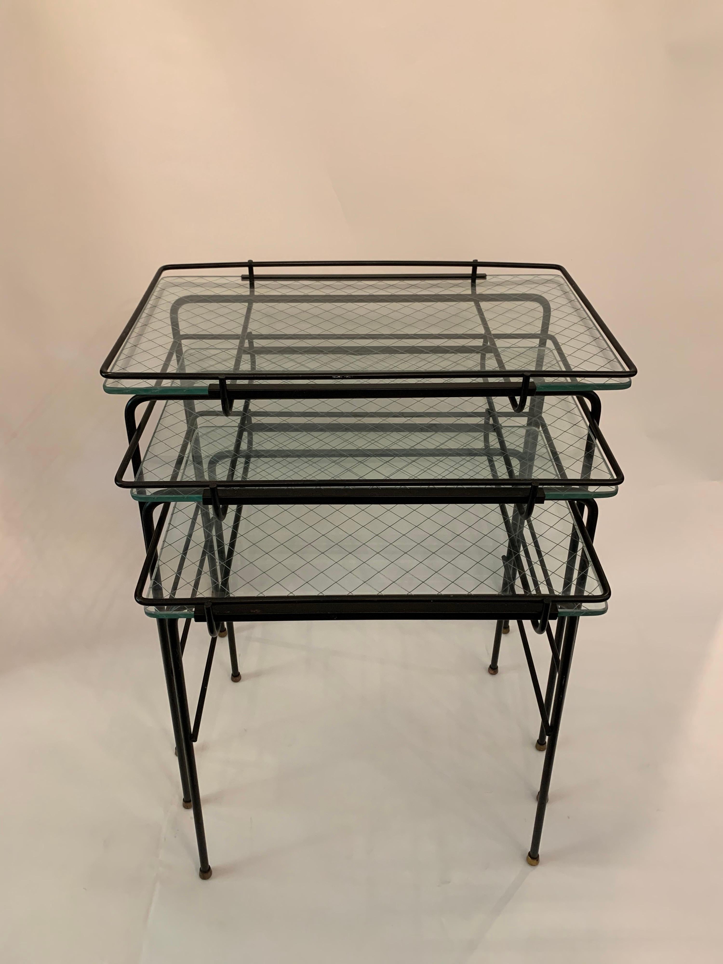 These are a set of 3 vintage French nesting tables very much in the manner of Mathieu Matégot. The black metal frames, brass ball feet and lattice glass table tops.

Measures: Small 18.5 H x 15.75 W x 11.75 D
Medium 20.5 H x 17.75 W x 11.75