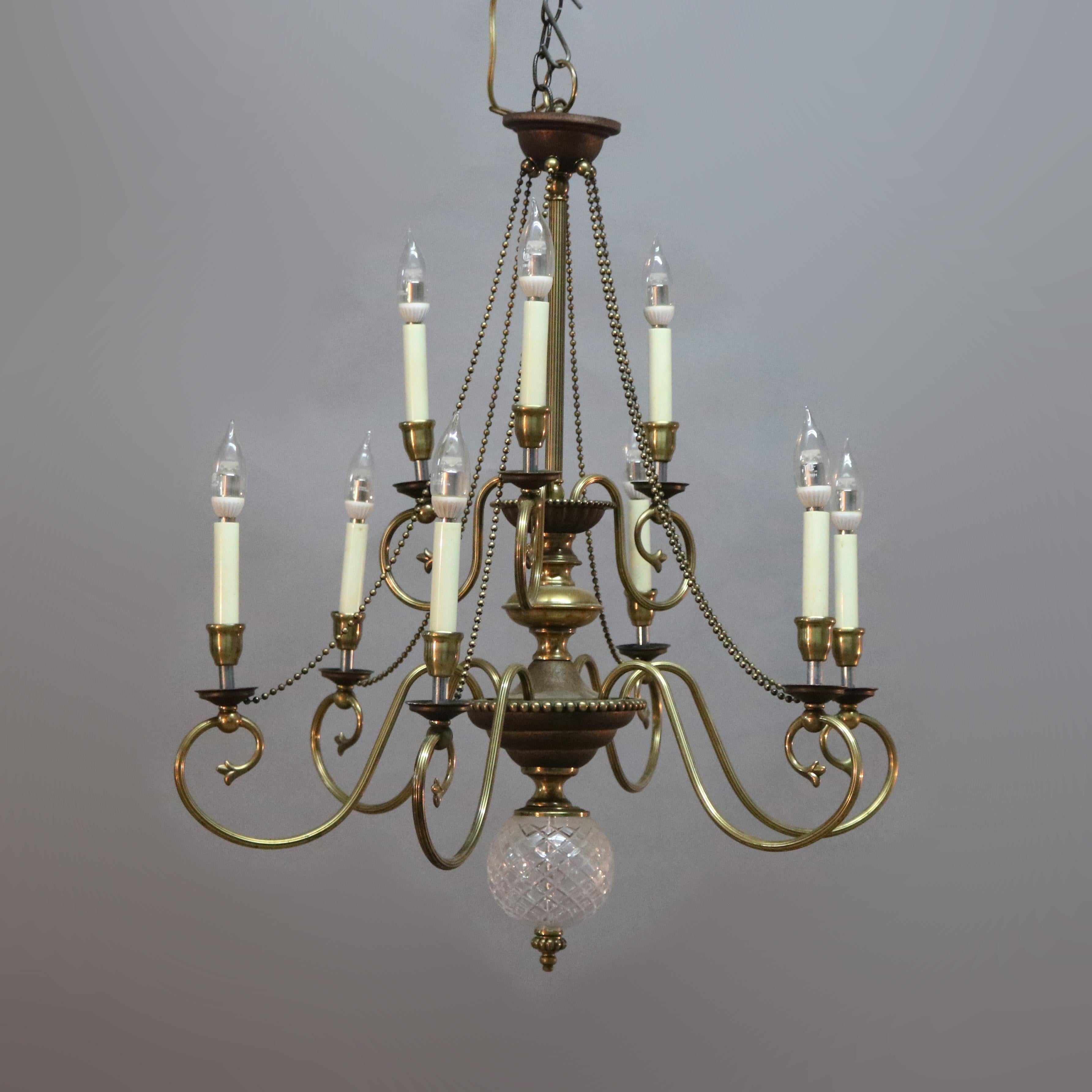 A vintage French chandelier offers tiered brass frame with scroll form arms terminating in nine candle lights with strung bead garland and crystal drop finial, 20th century

Measures: 30.5