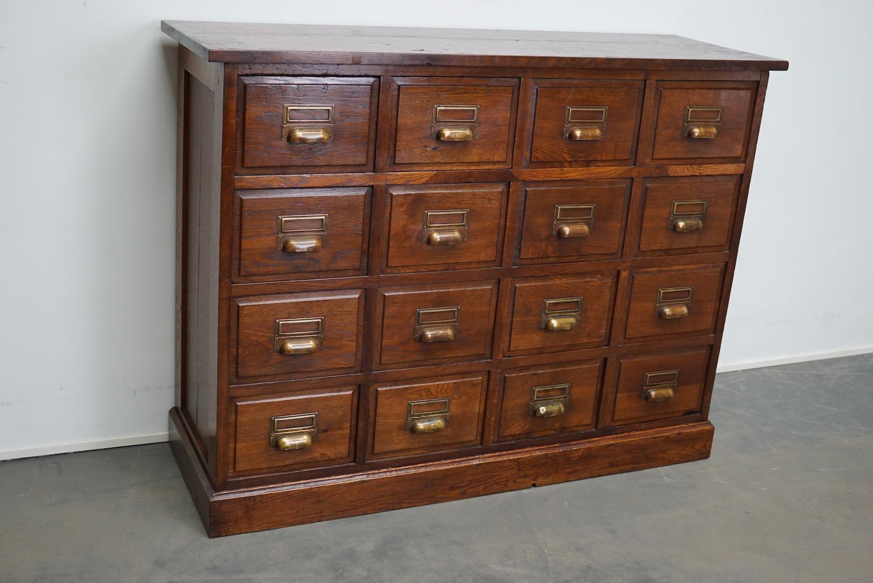 This apothecary / filing cabinet was produced during the 1930s in France. This piece features 16 drawers from oak with brass pulls. The interior dimensions of the drawers are: D x W x H 32 x 23 x 18 cm.