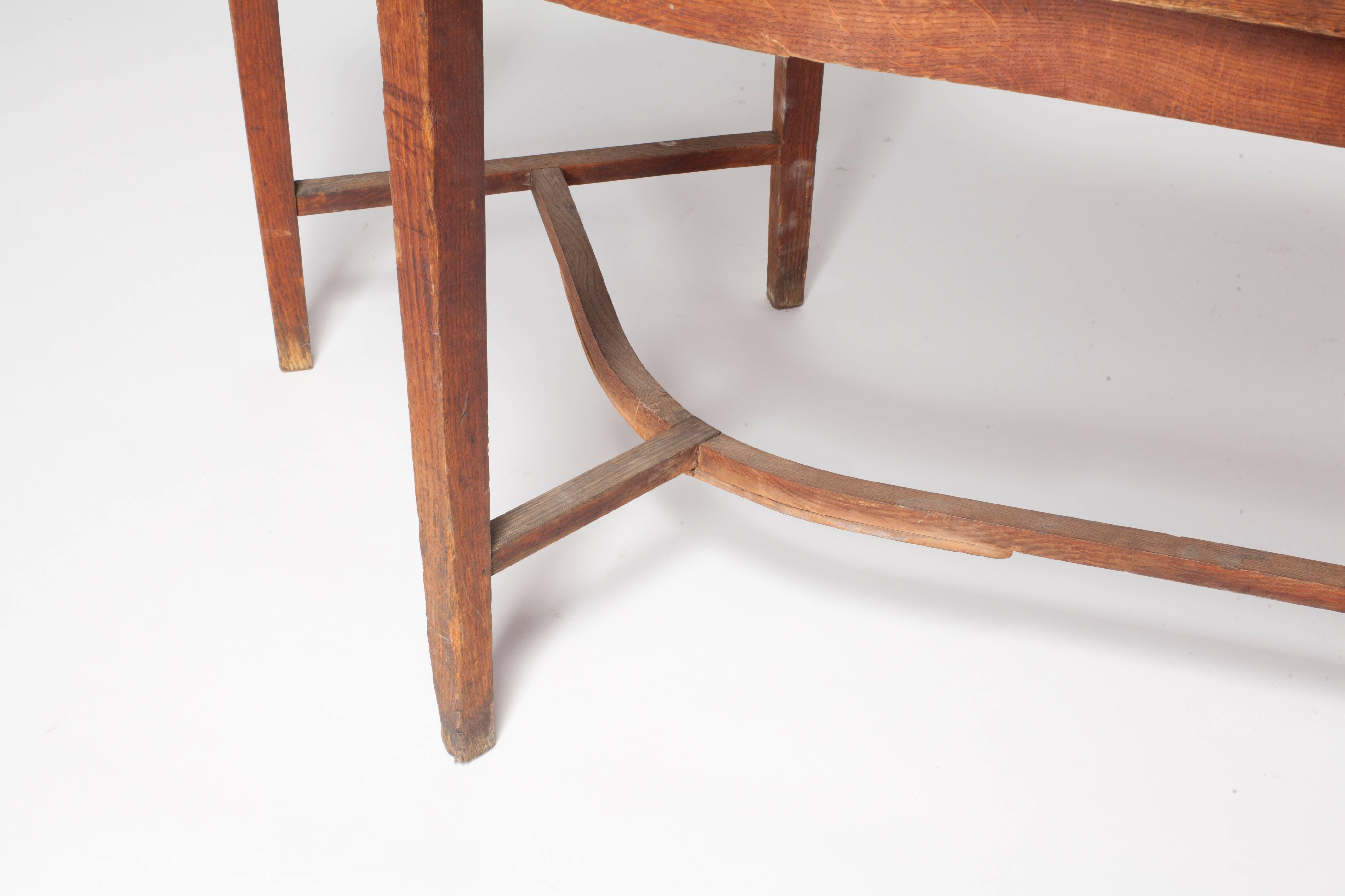 Vintage French oak curvilinear sorting table with tall tapered legs with lower stretcher.