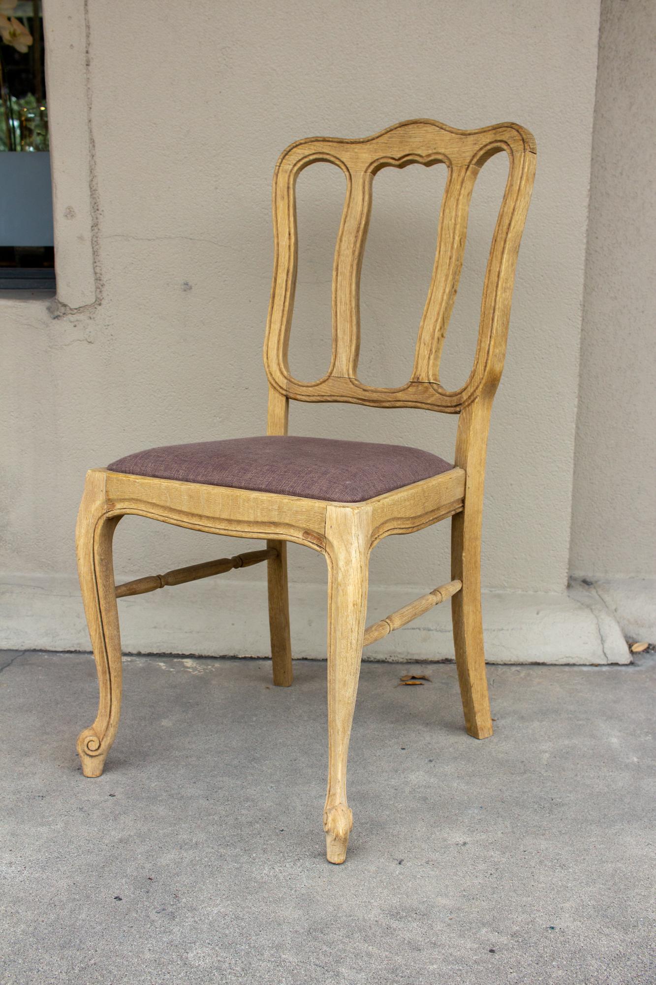 A wonderful set of six French Oak dining chairs with linen seats-- sourced in France, these chairs have been stripped of their original finish, allowing the details of the carving to be revealed. 

Each chair measures 18