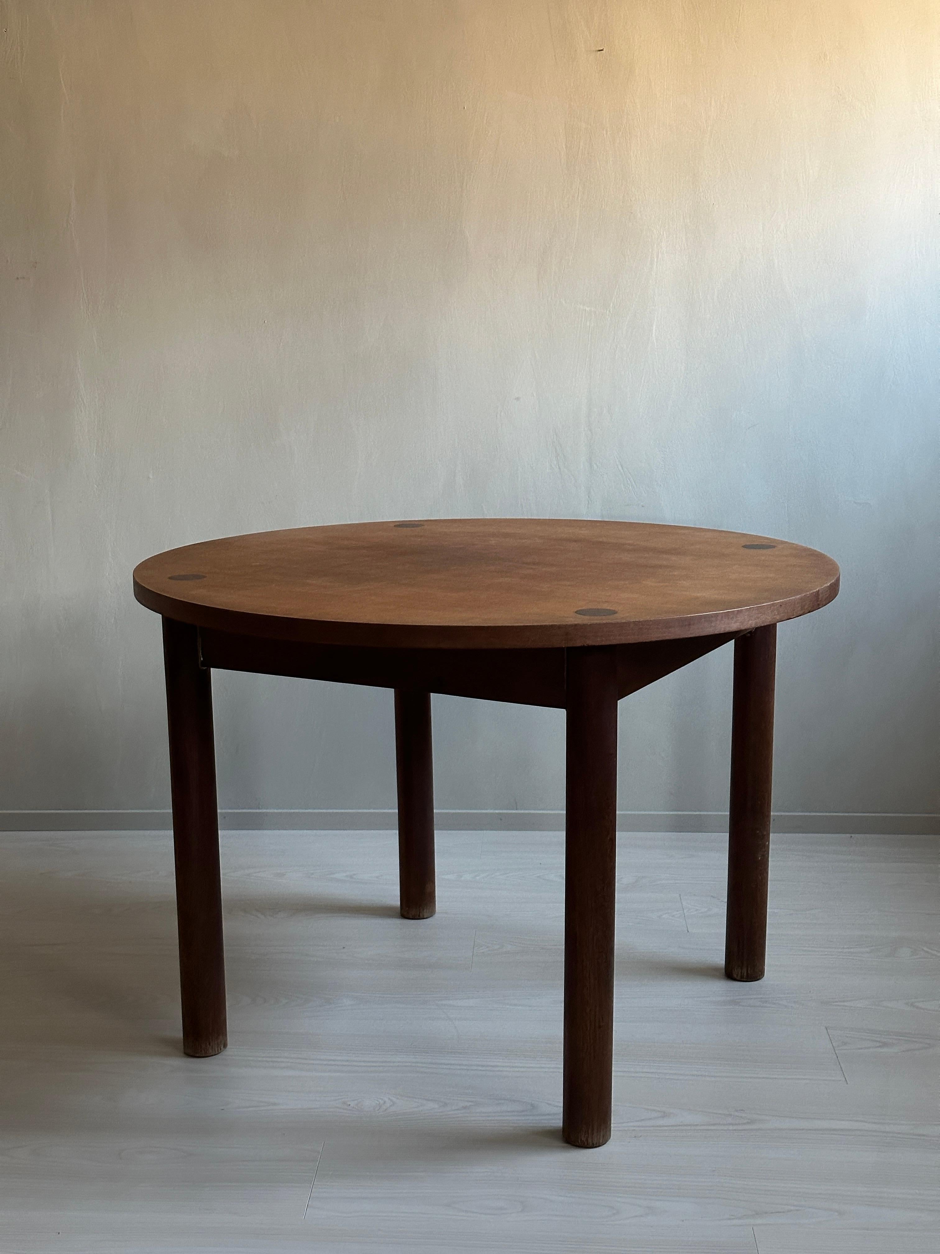 This beautiful round vintage dining table is a true masterpiece of design, inspired by the legendary French architect and designer, Charlotte Perriand. The table is made of dark stained oak, and it was originally crafted in France during the 1950s.