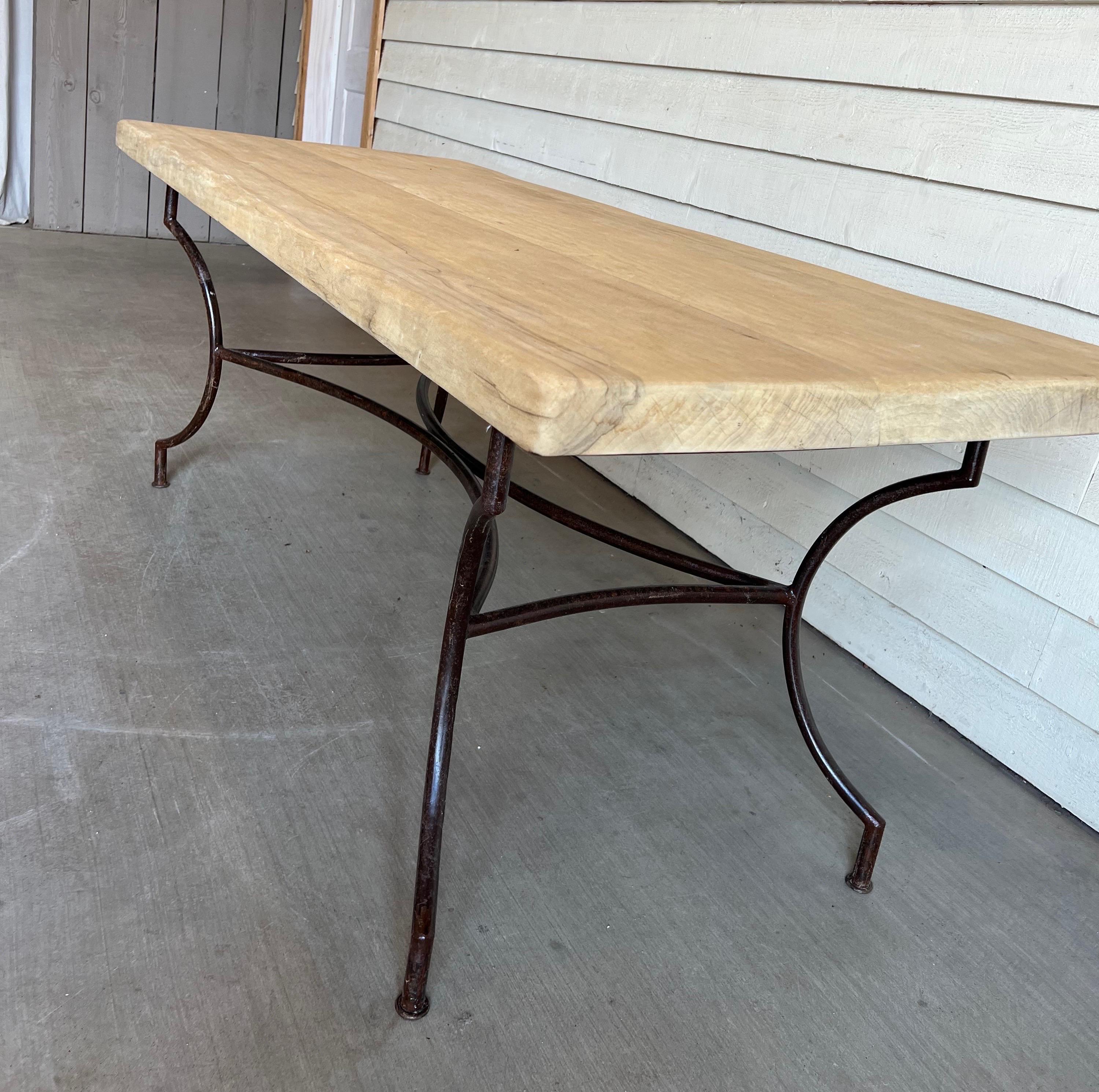 This vintage French dining table includes a very thick and heavy oak top that's been stripped and bleached and sits atop a hand crafted iron base. This piece is very sturdy and has lovely lines. Would also be beautiful as a large scale desk.