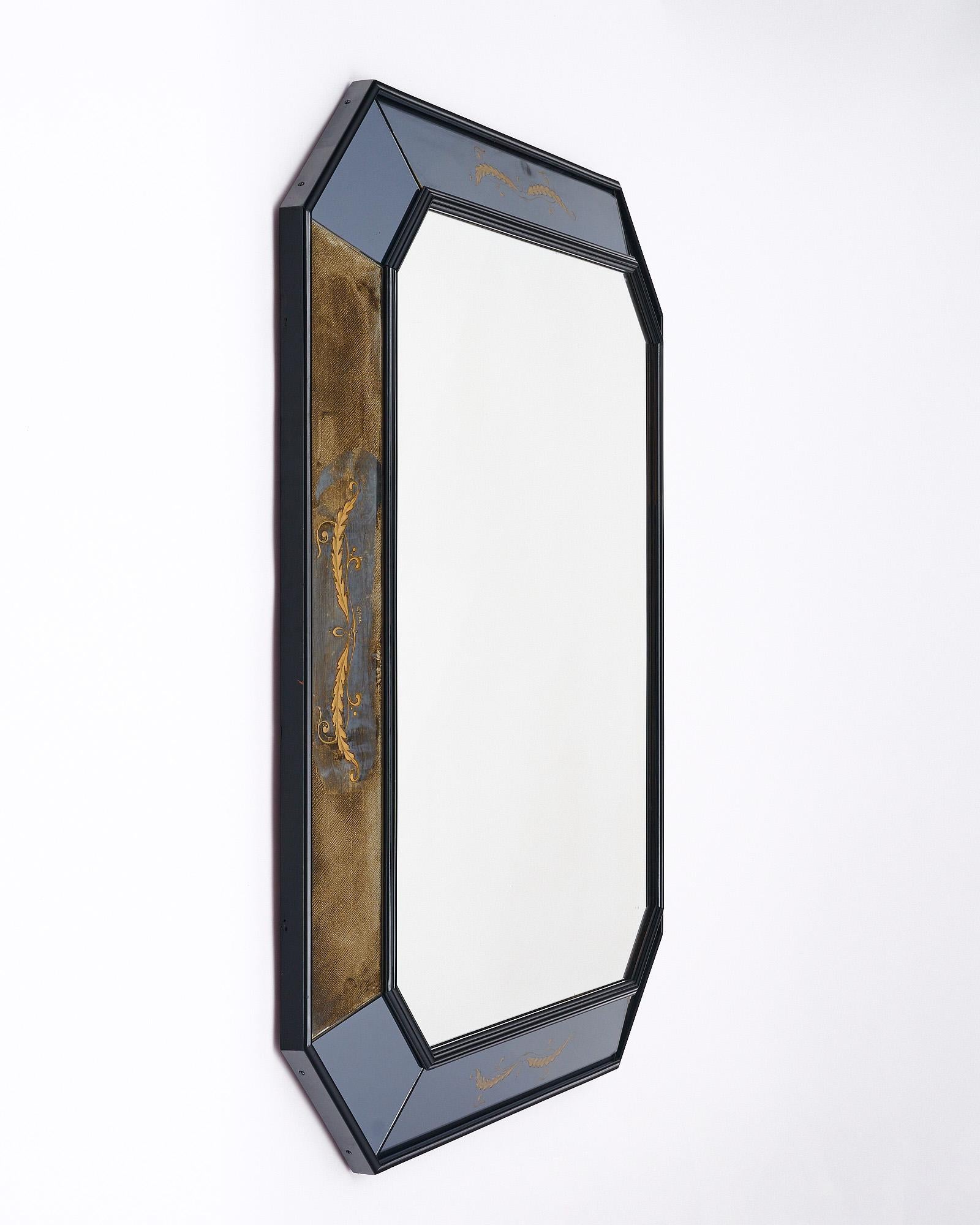 Miroir de France présentant un cadre octogonal à facettes avec des panneaux de miroir églomisé. Le cadre est en bois de noyer ébonisé.
