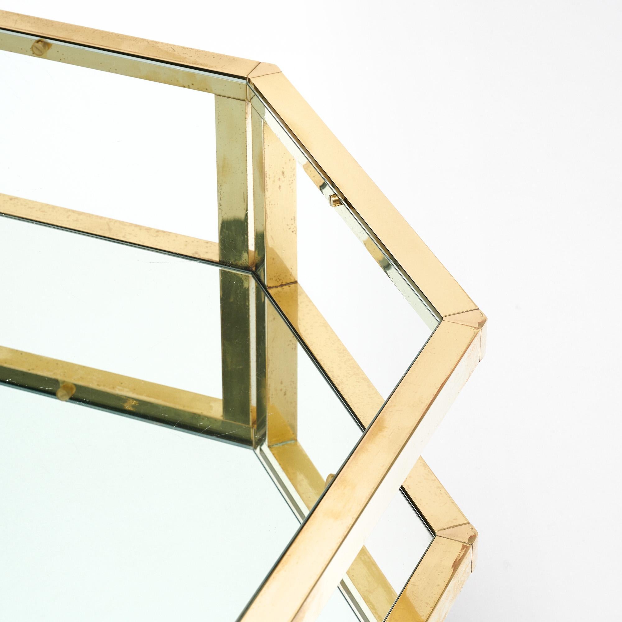 Mesa de centro francesa con estructura de latón y tapa de cristal transparente. El estante inferior es de cristal. Nos atrajo su singular forma octogonal y su sólida artesanía. La mesa está en excelentes condiciones de época, con un desgaste