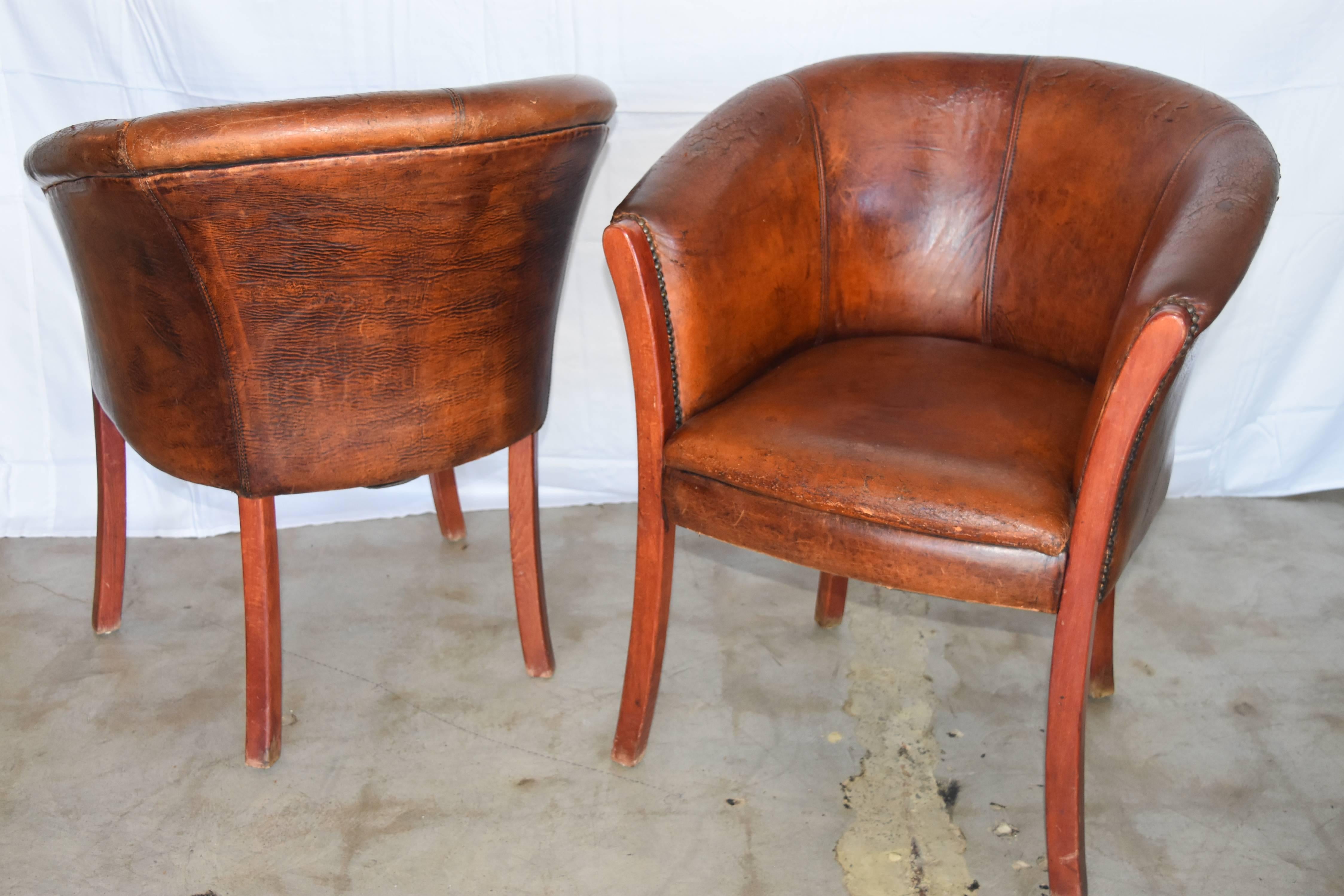 These adorable club chairs from Europe have that really rubbed and well used look like they've been smoked in for 100 years. The color of the leather is a beautiful cognac color and really in pretty good condition for their age. One does have about