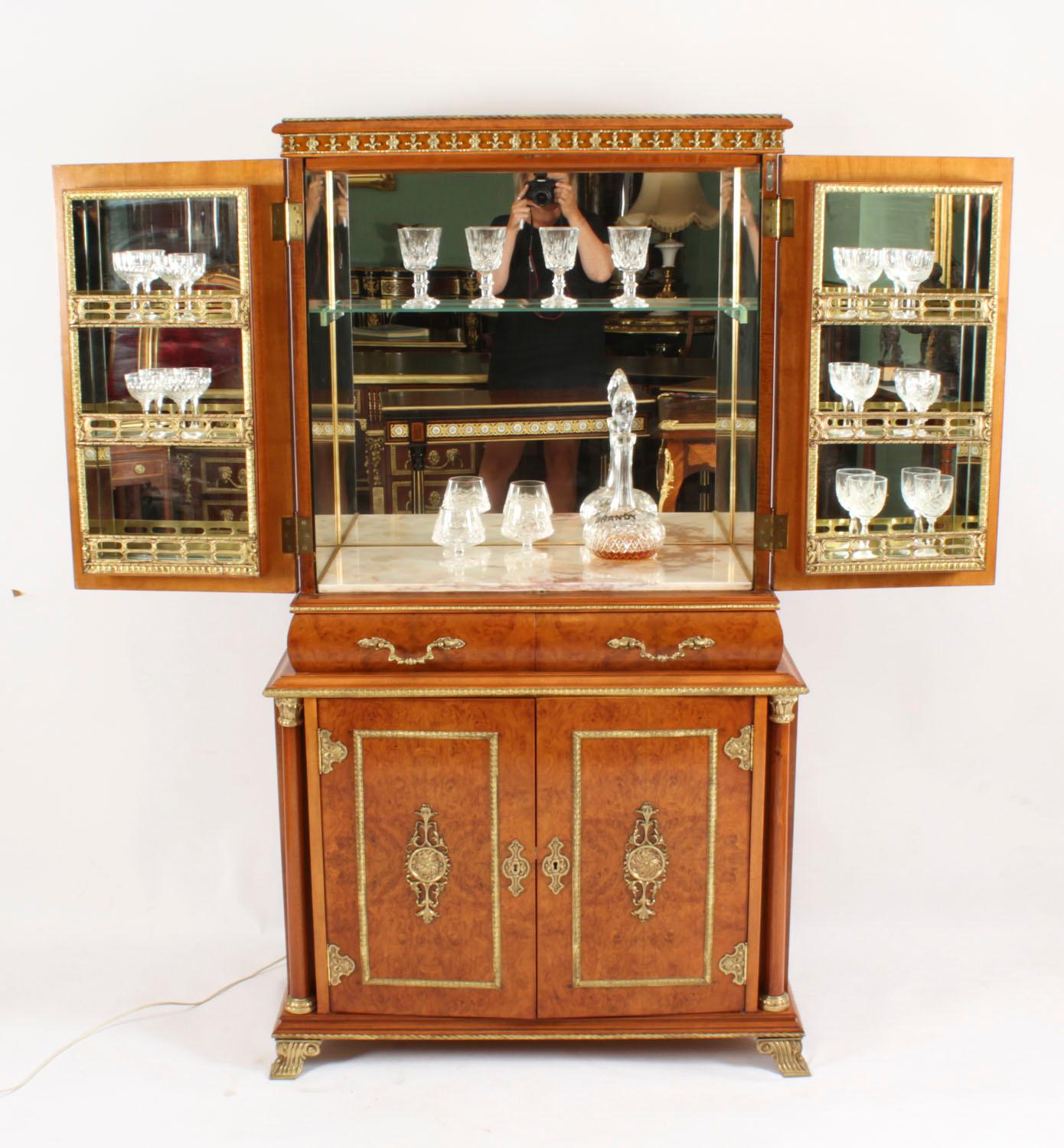 This is a stupendous vintage French burr walnut and ormolu mounted cocktail cabinet with fitted and mirrored and alabaster interior, of the highest quality and dating from Circa 1930.
 
The upper part comprises a pair of doors that each has three