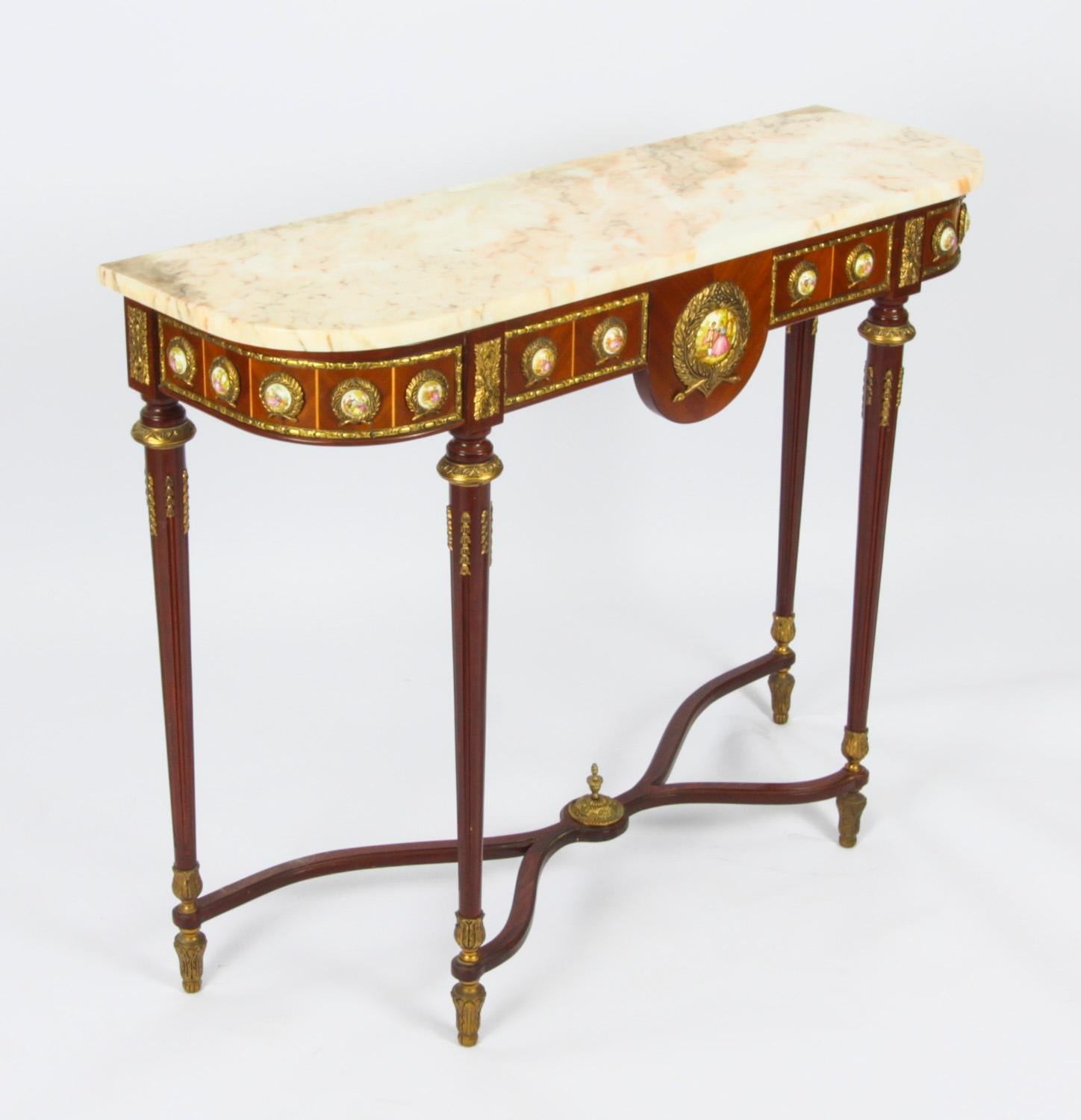 This is an elegant French Louis Revival console table dating from the mid 20th Century.

This magnificent piece is crafted from wood with stunnning ormolu mounts and features fourteen small Sevres style porcelain plaques depicting courting couples