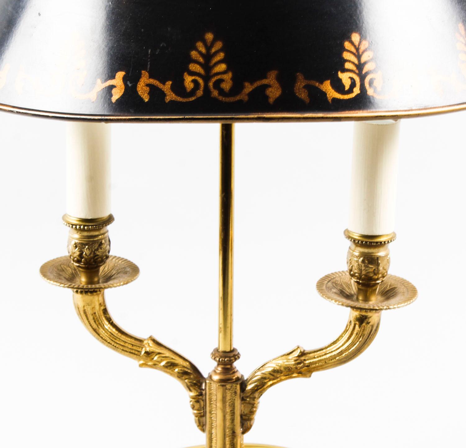 This is a beautiful French bouillotte lamp in ormolu and toleware, circa 1950 in date.

The lamp features a black tôle shade with gold highlights. The base, which would hold the Bouillotte game pieces, is finely chased while the two arms rise out