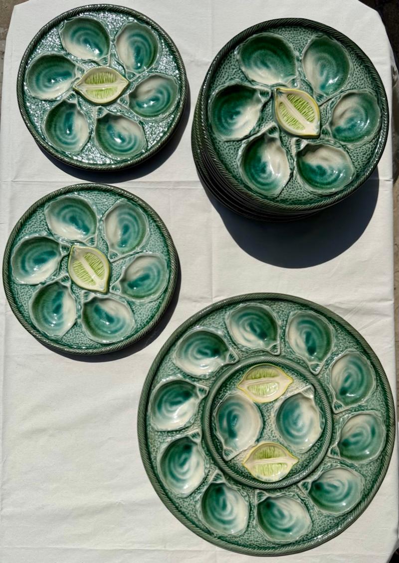 Ein charmantes französisches Austernservice, bestehend aus zehn einzelnen Tellern und einer großen Servierplatte, hergestellt aus glasierter Keramik von Sarreguemines, Frankreich, ca. Mitte des 20. Jahrhunderts. Jeder Teller ist mit sechs vertieften