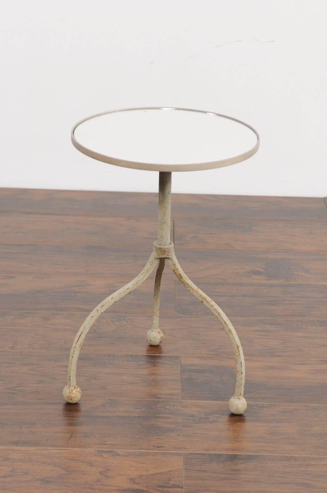 A French vintage painted iron round side table from the mid-20th century with tripod base and new mirrored top. This French side table features a circular top, supporting a new custom-made mirror. The table is raised on an interesting iron base,