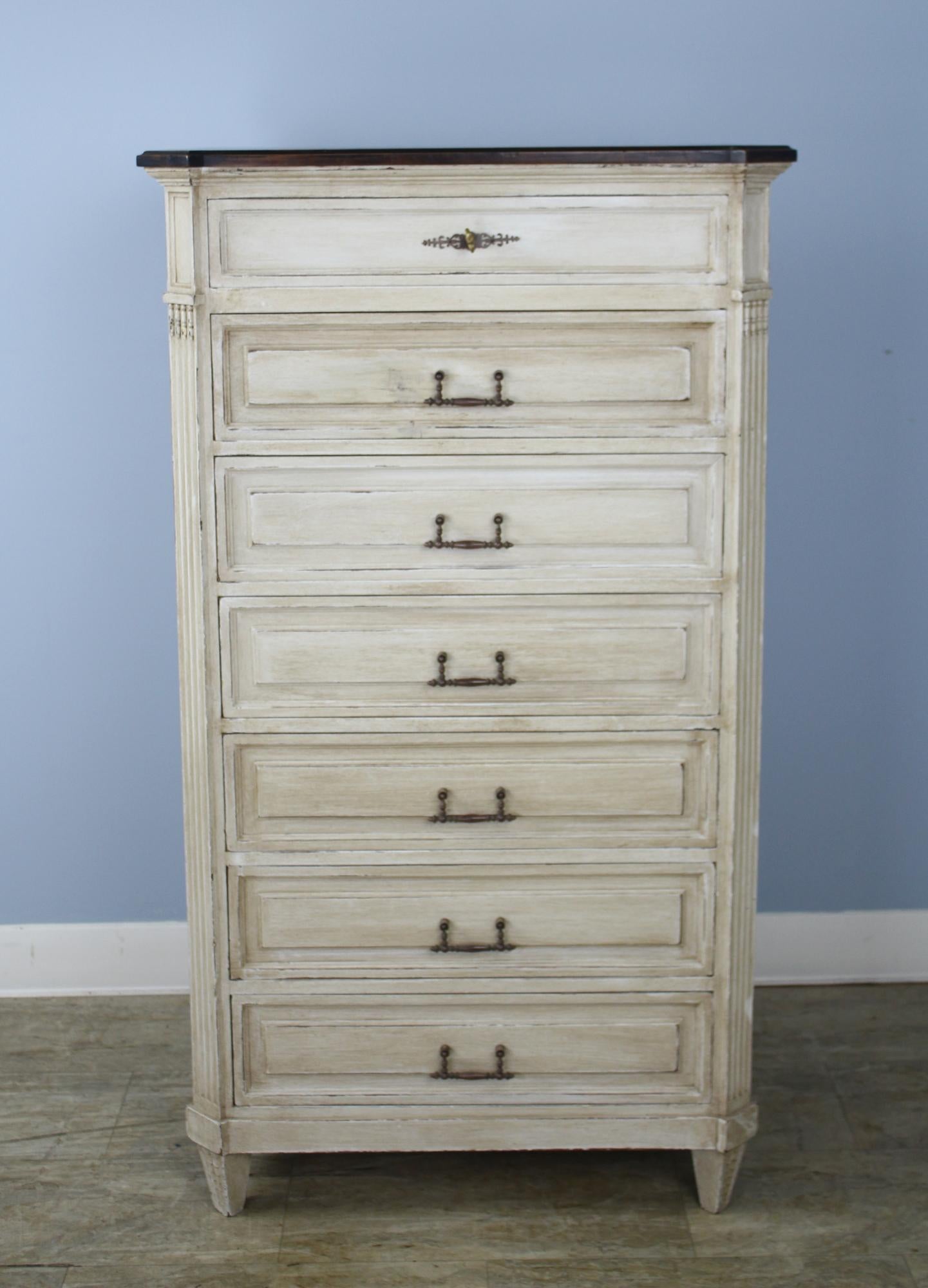 A tall seven drawer dresser, one for each day of the week. Dark wood top adds contrast. Original bronze handles. Paint has been refreshed.