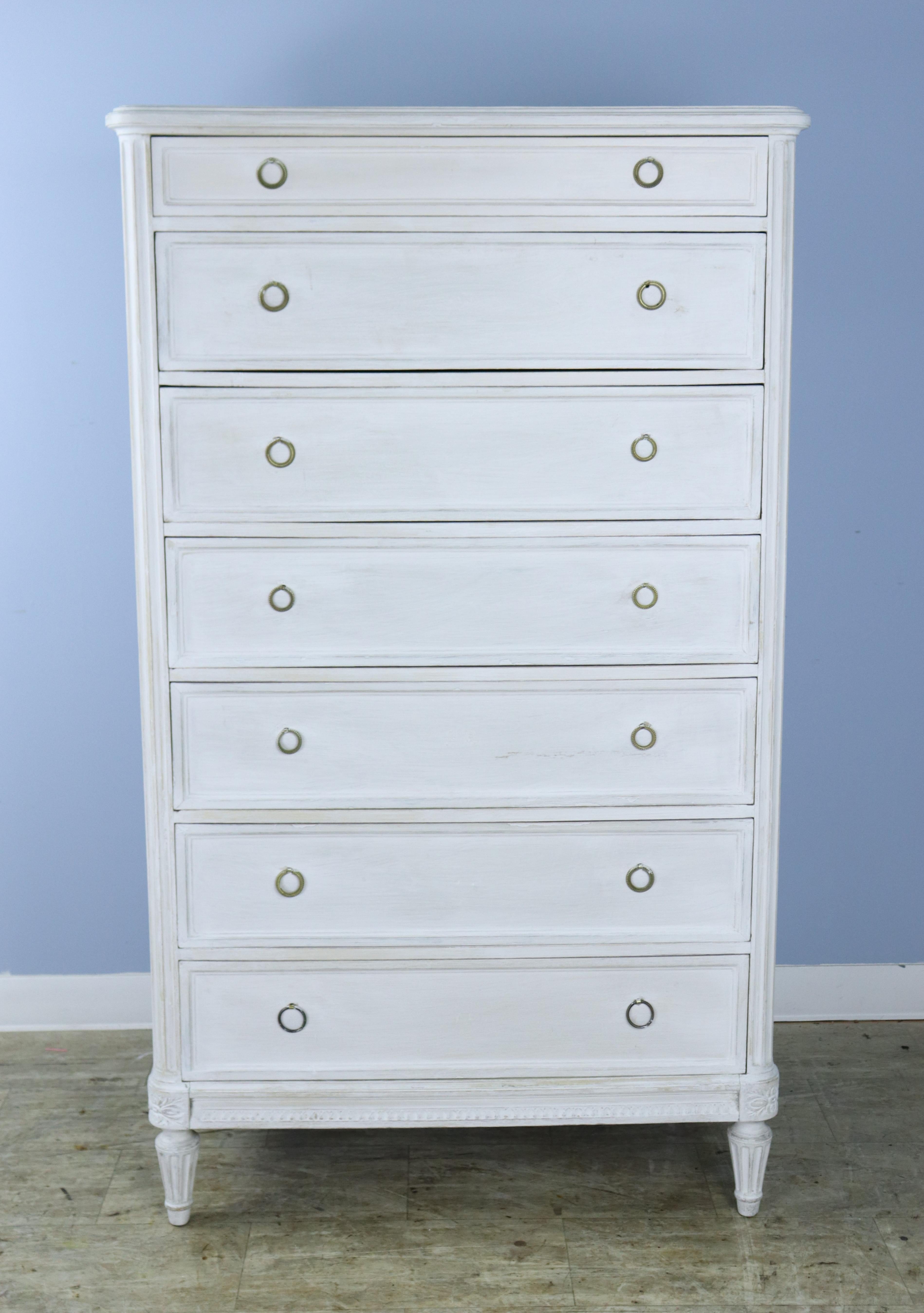 A tall seven drawer dresser, one for each day of the week.  Original bronze handles, with two replaced on the bottom drawer. Paint has been refreshed.