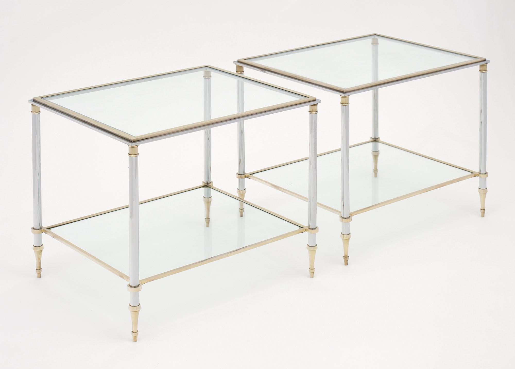 Pair of side tables from France made of steel and brass, featuring two clear glass shelves each. This pair has strong design and craftsmanship.