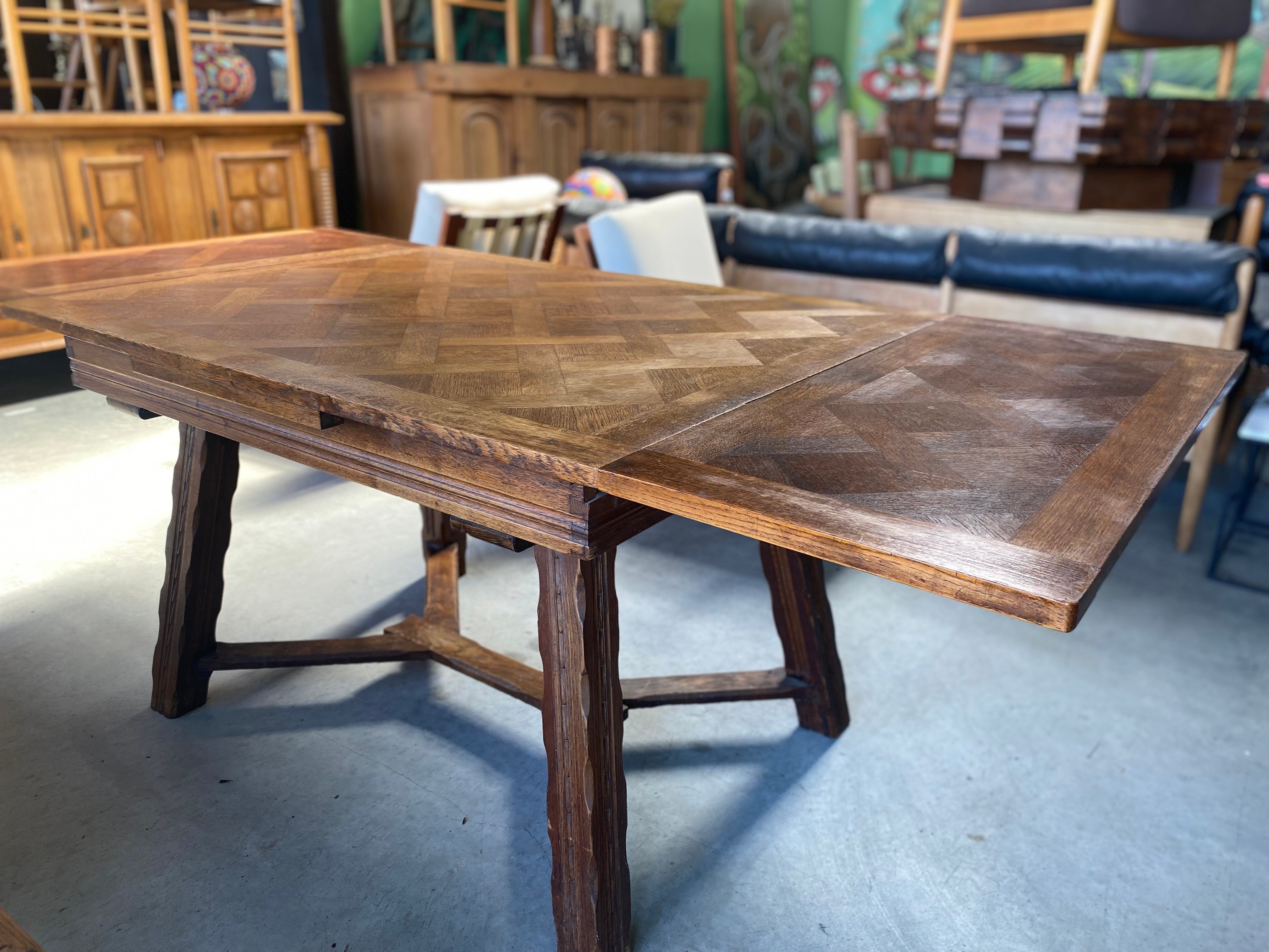 Vintage French parquet draw leaf / refractory dining table made of solid oak and features sculpted legs, circa 1960s. This mid-century modern dining table can sit six. 

Total length of table with leaves - 78.5 x 35.5