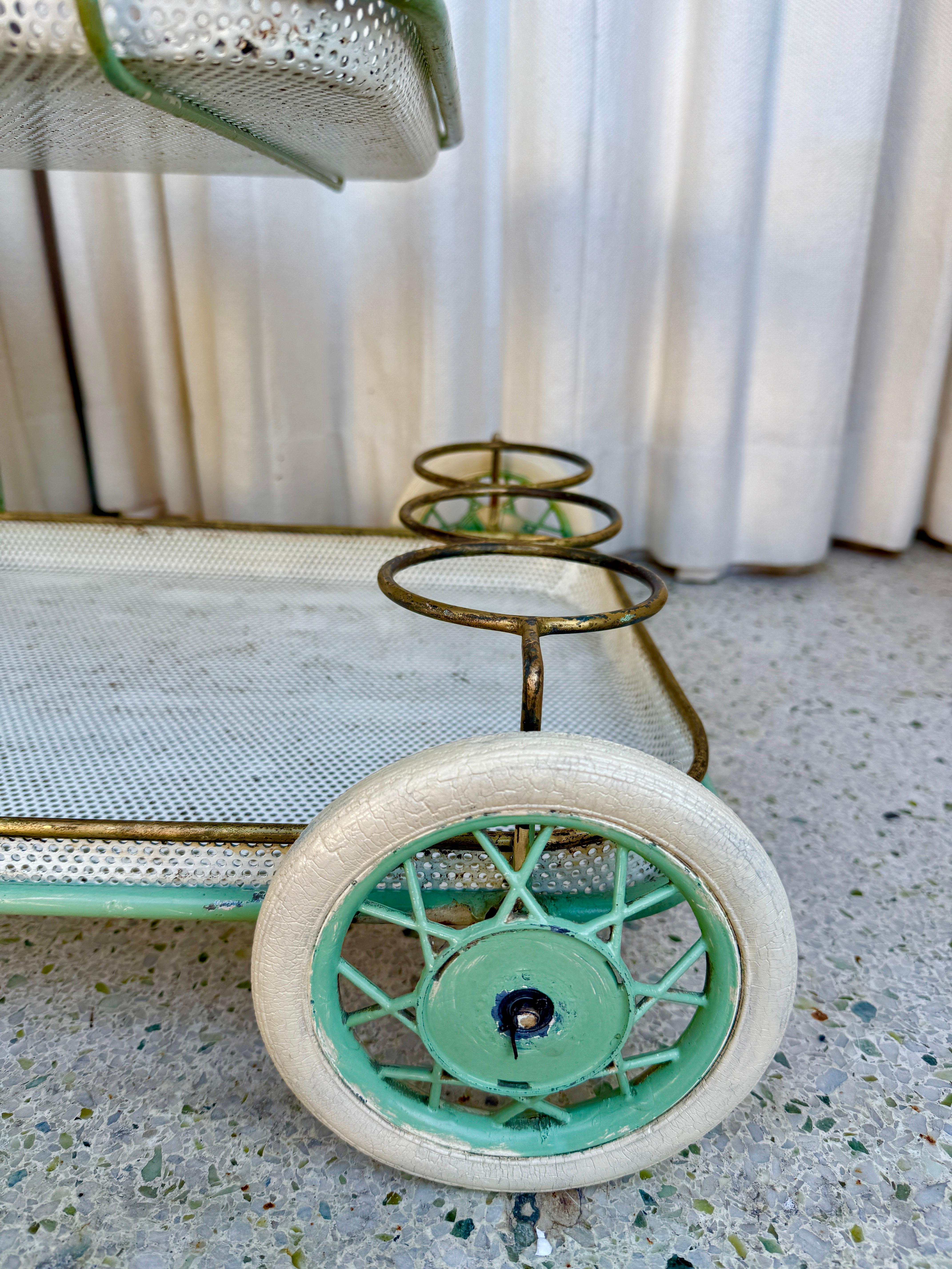 Very much in the style of Matthieu Mategot, this amazing original condition bar cart features THREE (3) perforated and brass trimmed removeable trays (SEE detail images).  Fantastic original green painted frame.
Additional Dimensions:  Mid-level