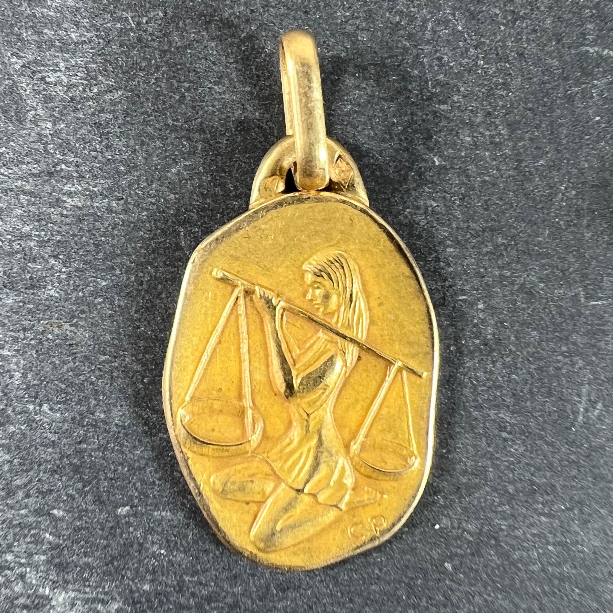 Colgante de oro amarillo de 18 quilates (18K) diseñado según el signo zodiacal de Libra, que representa a una mujer arrodillada equilibrando una balanza sobre su hombro. Firmado CP, estampado con la marca del águila para oro de 18 quilates y