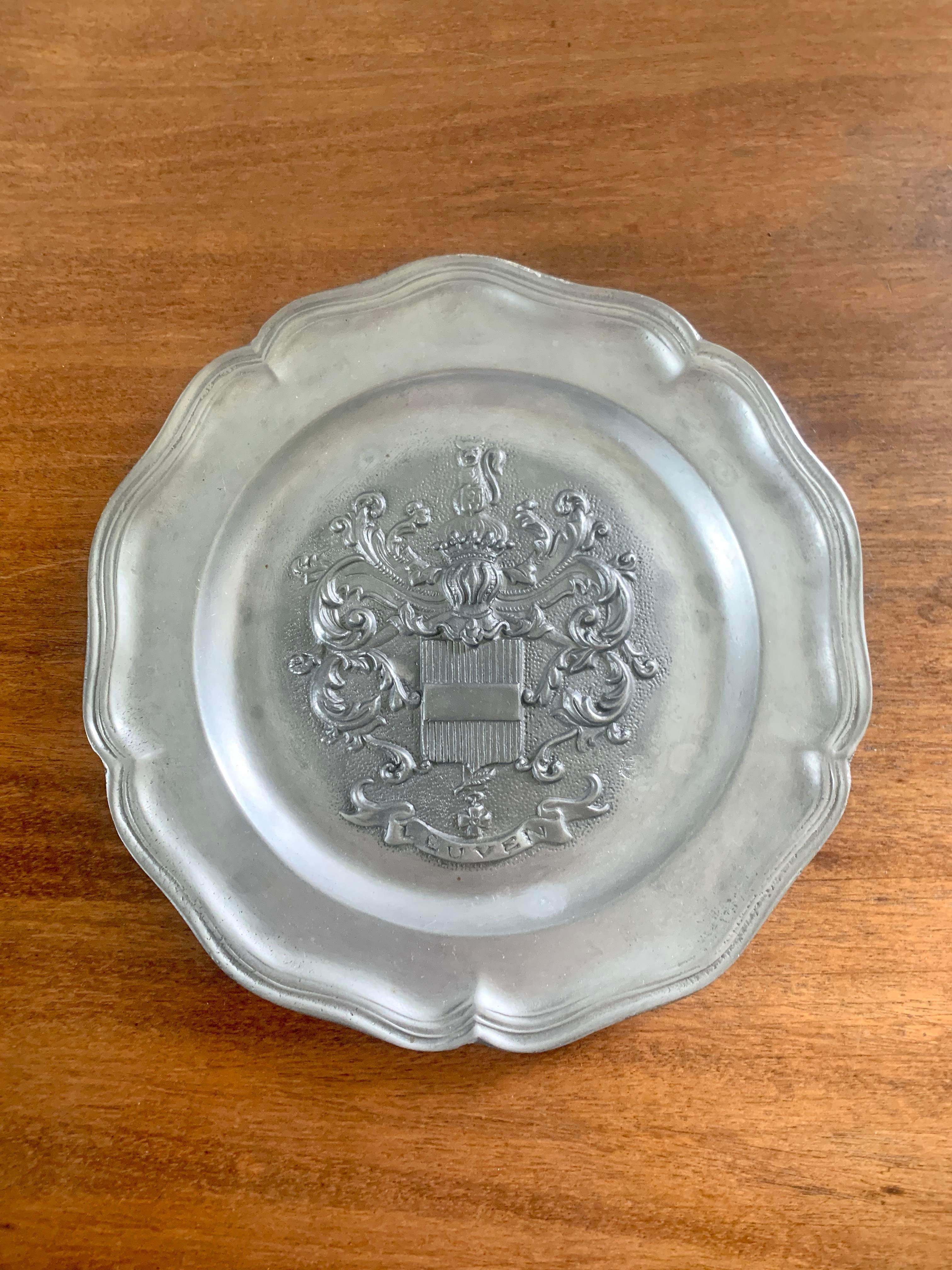 A beautiful pewter wall plate featuring a coat of arms of 