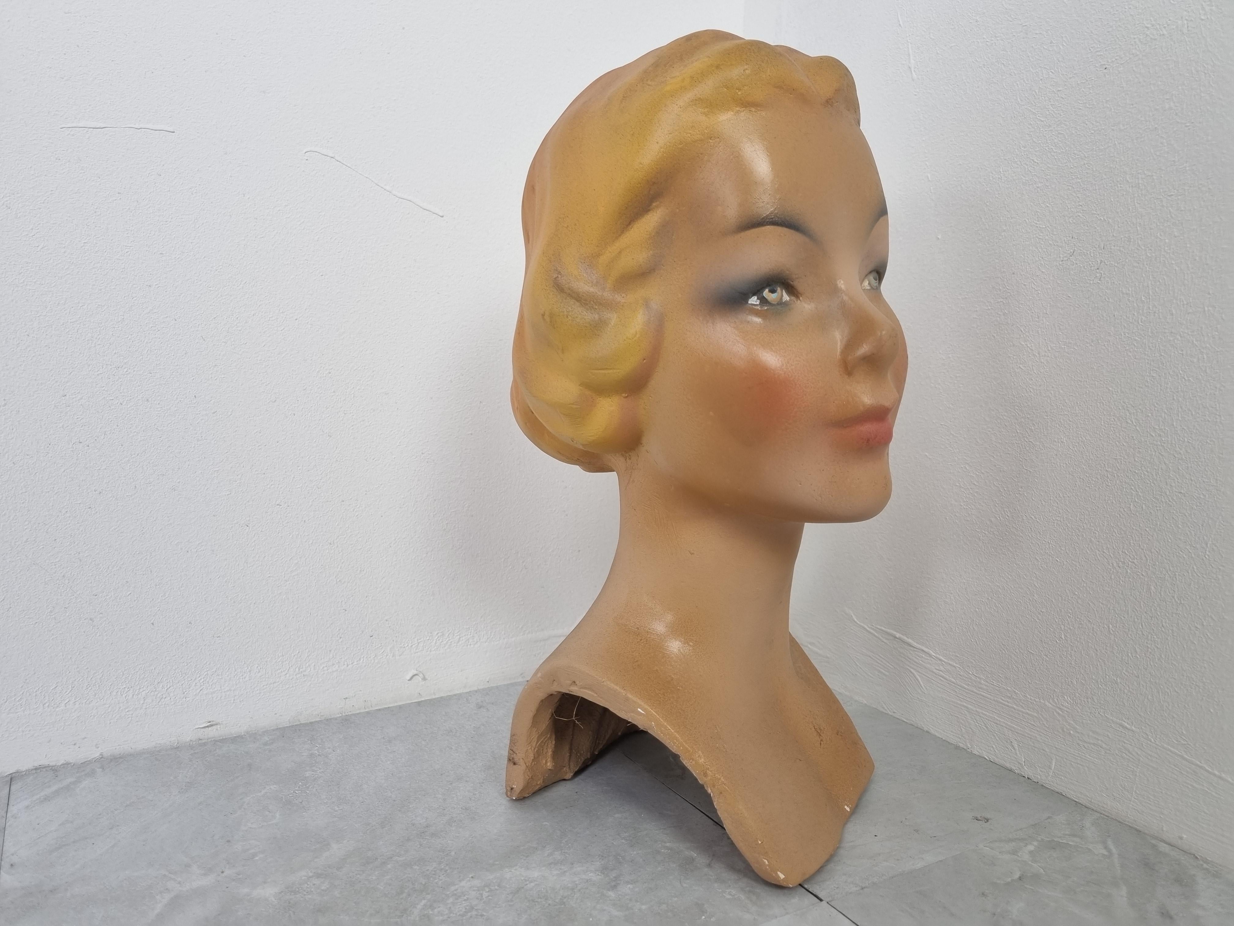 Beautiful female mannequin head made from plaster serving as an advertising bust in a shop.

It was used to be displayed at a shopcounter or vitrine.

Comes from a lot acquired from a clothes shop that stopped activities.

Great decorative