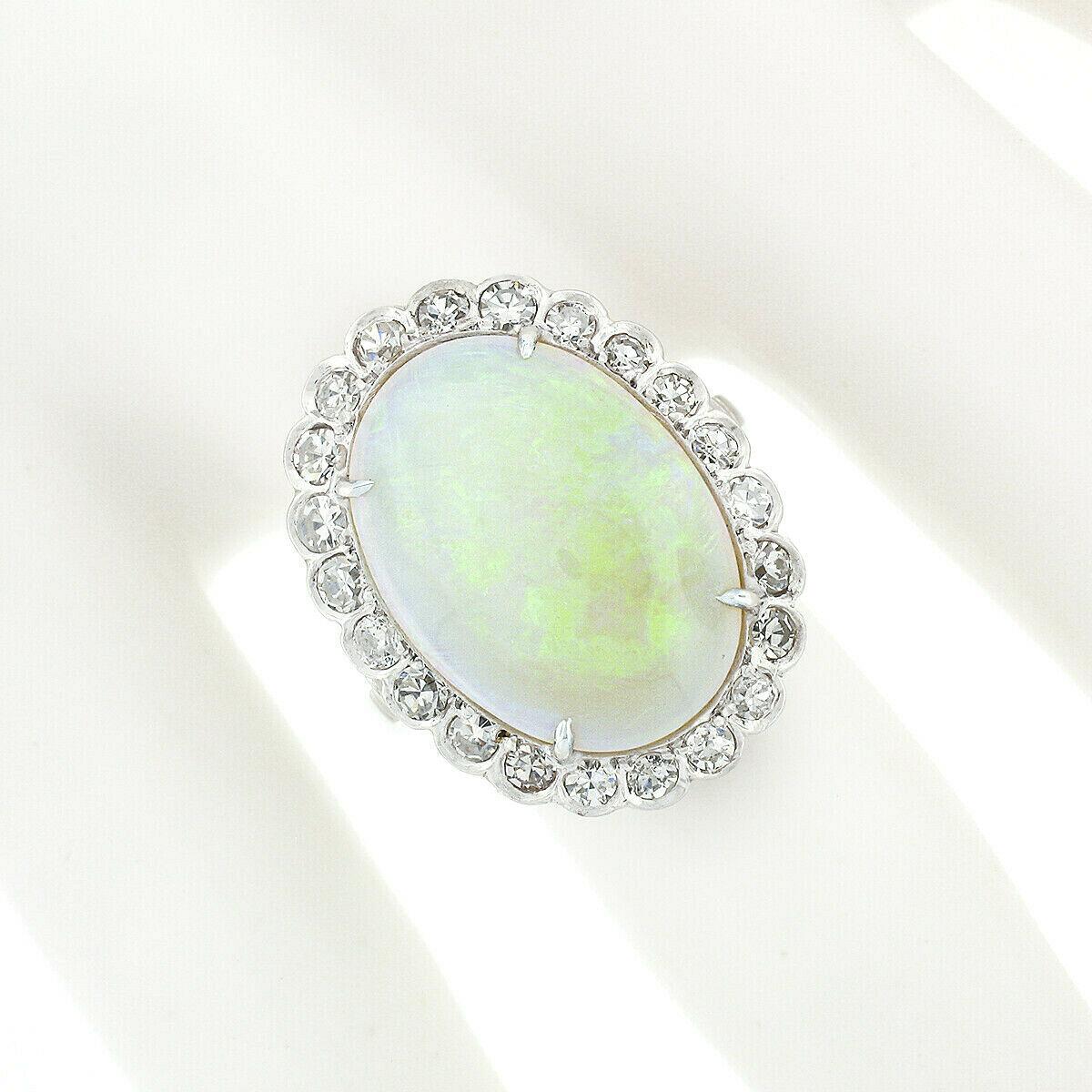This magnificent fancy vintage ring was crafted in France from solid 950 platinum and features a breathtaking, GIA certified, natural opal gemstone neatly and elegantly claw-prong set at the center of a delicate halo design. The white opal is in