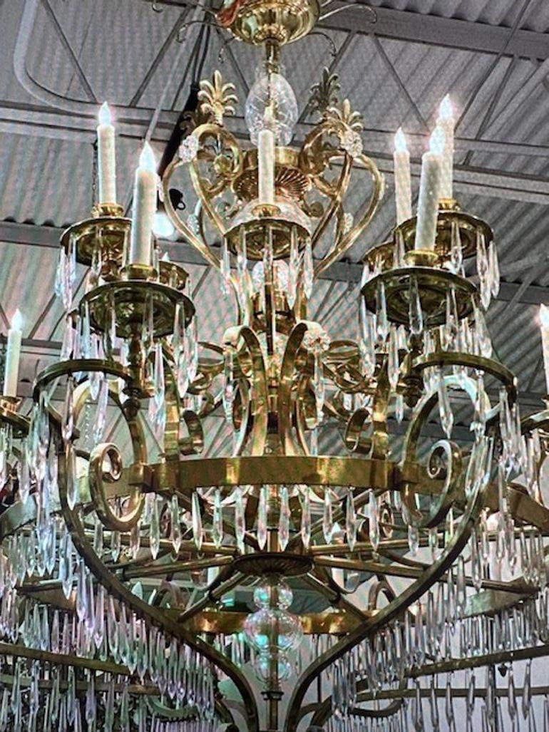 Massive vintage French polished brass and crystal 32 light chandeliers. (2 available).  Removed from a prominent Paris Hotel, Circa 1940. The chandeliers have been professionally rewired, comes with matching chain and canopy. It is ready to hang!