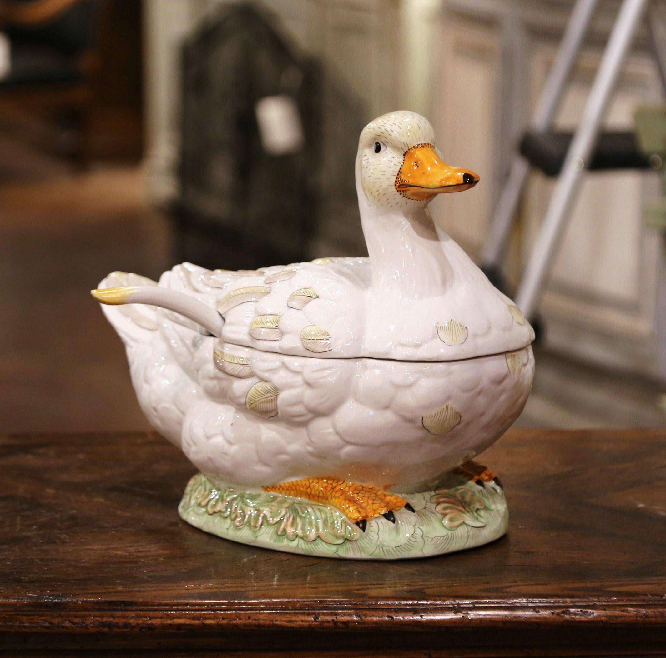 Decorate a dining table with this elegant and colorful Majolica centerpiece. Crafted in France circa 1980, the ceramic tureen is shaped as a duck resting on bed of grass. The lid opens and reveal the inside ladle. The decorative dish is in excellent