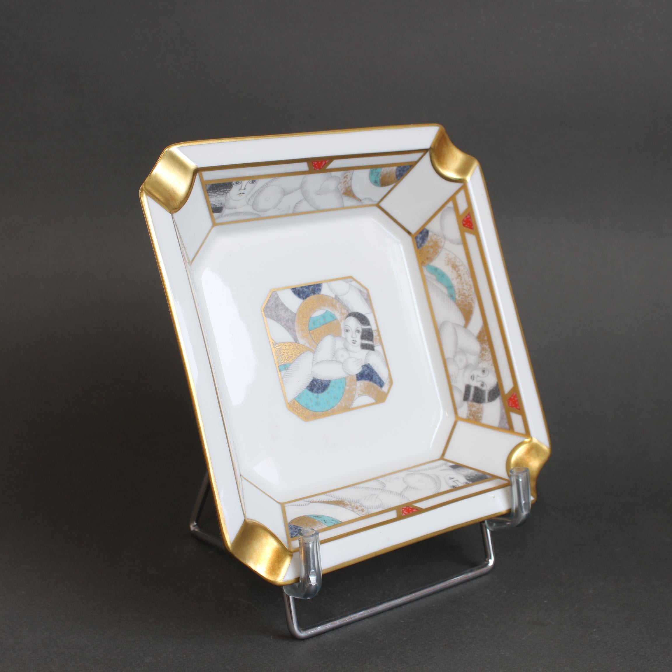 A fine vintage porcelain-gilt ashtray (circa 1990s) by Bernardaud, the storied Limoges manufacturer established in 1863. This one depicts a voluptuous Parisienne with a 1920s hairstyle, the heyday of the art deco era. This splendid porcelain piece