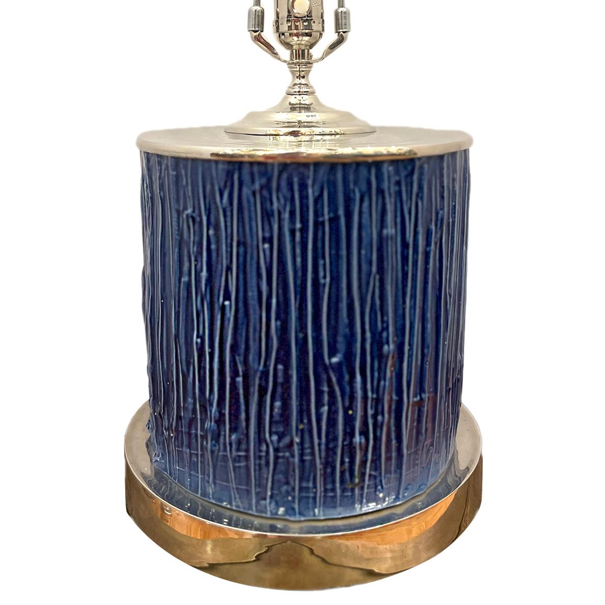 Una lámpara francesa de porcelana azul de hacia 1960.

Medidas:
Altura del cuerpo: 11
Altura hasta el apoyo de la sombrilla: 20.5
Diámetro: 9,75